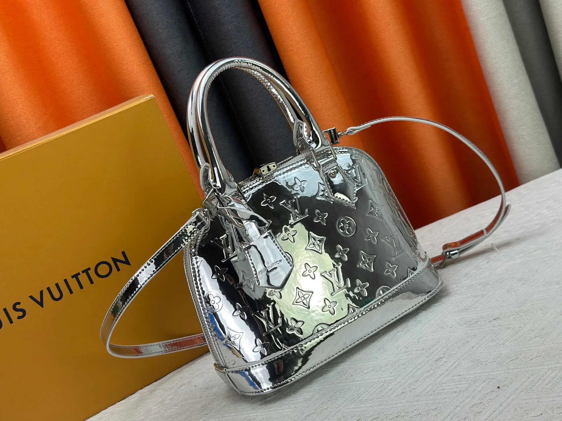 P300 M11835 M53151 M53152 The Alma medium handbag of the LVSki series draws inspiration from the Louis Vuitton archive hard box, rendering a new Monogram Miroir effect on the Monogram embossed coated canvas, highlighting the concept of retro futurism. Spacious interior patch pockets ensure organized storage. Size: 23.5x17.5x11.5cm