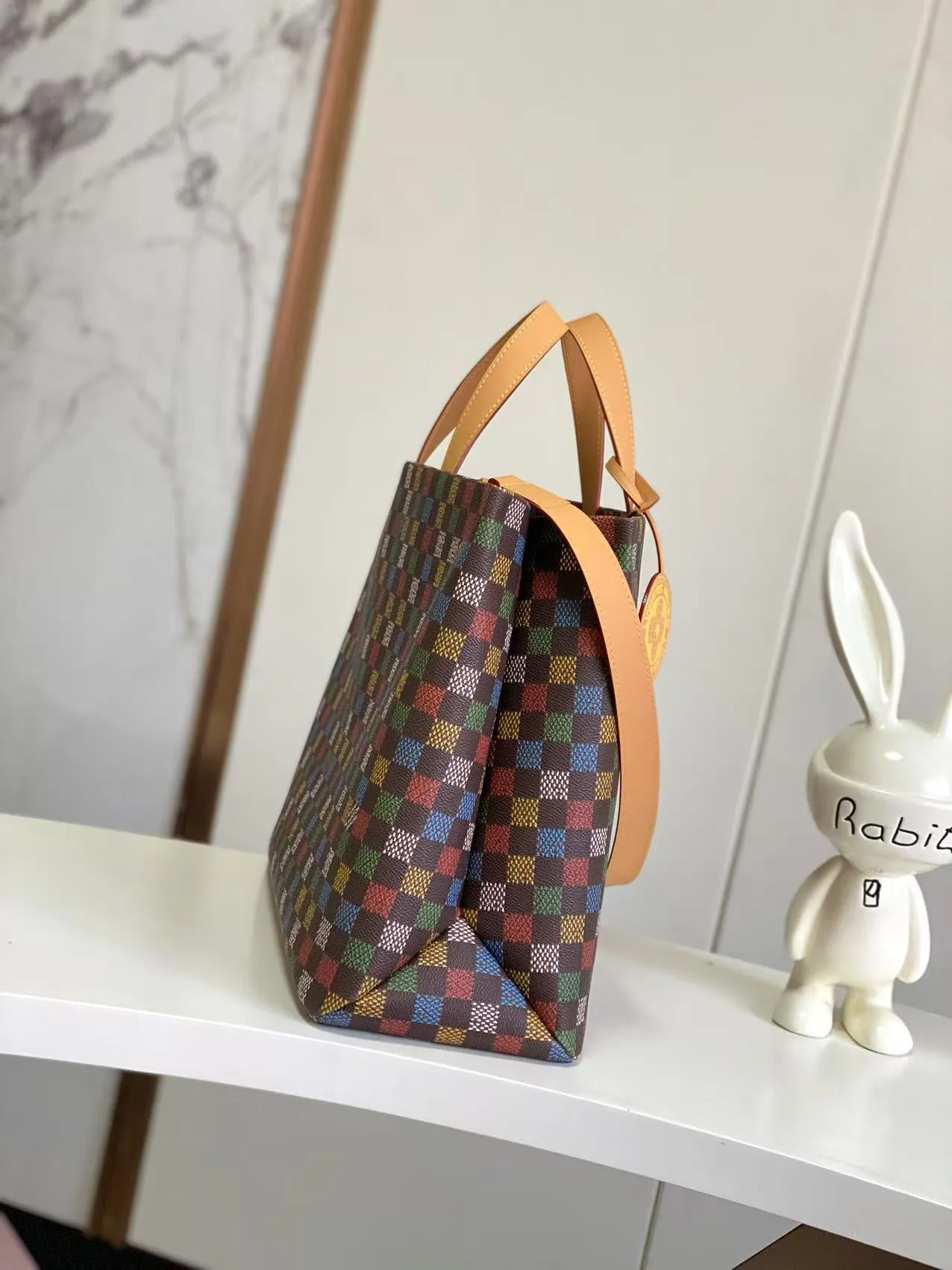 💰1100 Top Original N00192 Shopper Tote handbag design is inspired by Louis Vuitton's classic shopping bag, characterized by the same clean lines and contrasting Louis Vuitton letter logo. Crafted from LVers Damier Ebene coated canvas, this bag features Pharrell Williams' colorful reinterpretation of the Damier pattern (inspired by a classic design created by Georges Vuitton in 1888). Two top handles and a detachable shoulder strap provide a flexible carrying method that combines practicality with unique charm. Dimensions: 32 x 16 x 40 cm
