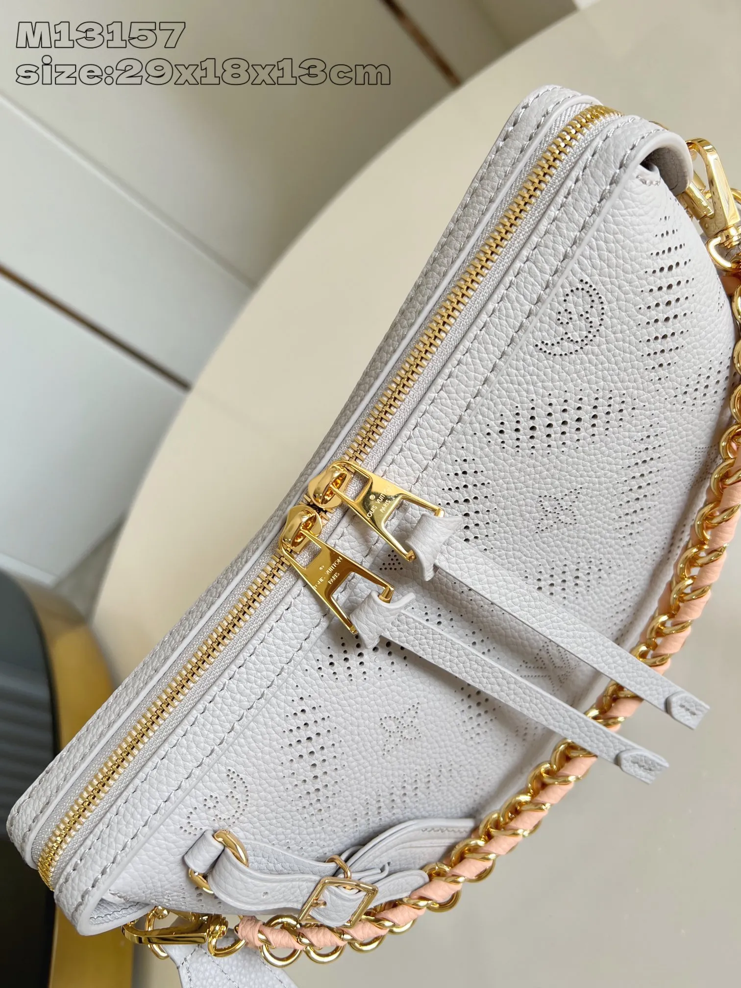 💰1180 (top-grain leather) Top-quality original item [Exclusive real shot M13157 gray] This Hand It All small handbag uses cow leather to interpret the brand's Bloom elements, integrates floral imagery into the perforated Monogram pattern, and upgrades the classic style with contrasting color brands. The inner patch pocket is convenient for storing mobile phones, and the woven chain allows for flexible switching between cross-body or shoulder wear. 18 x 13 x 29 cm (height x width x length)