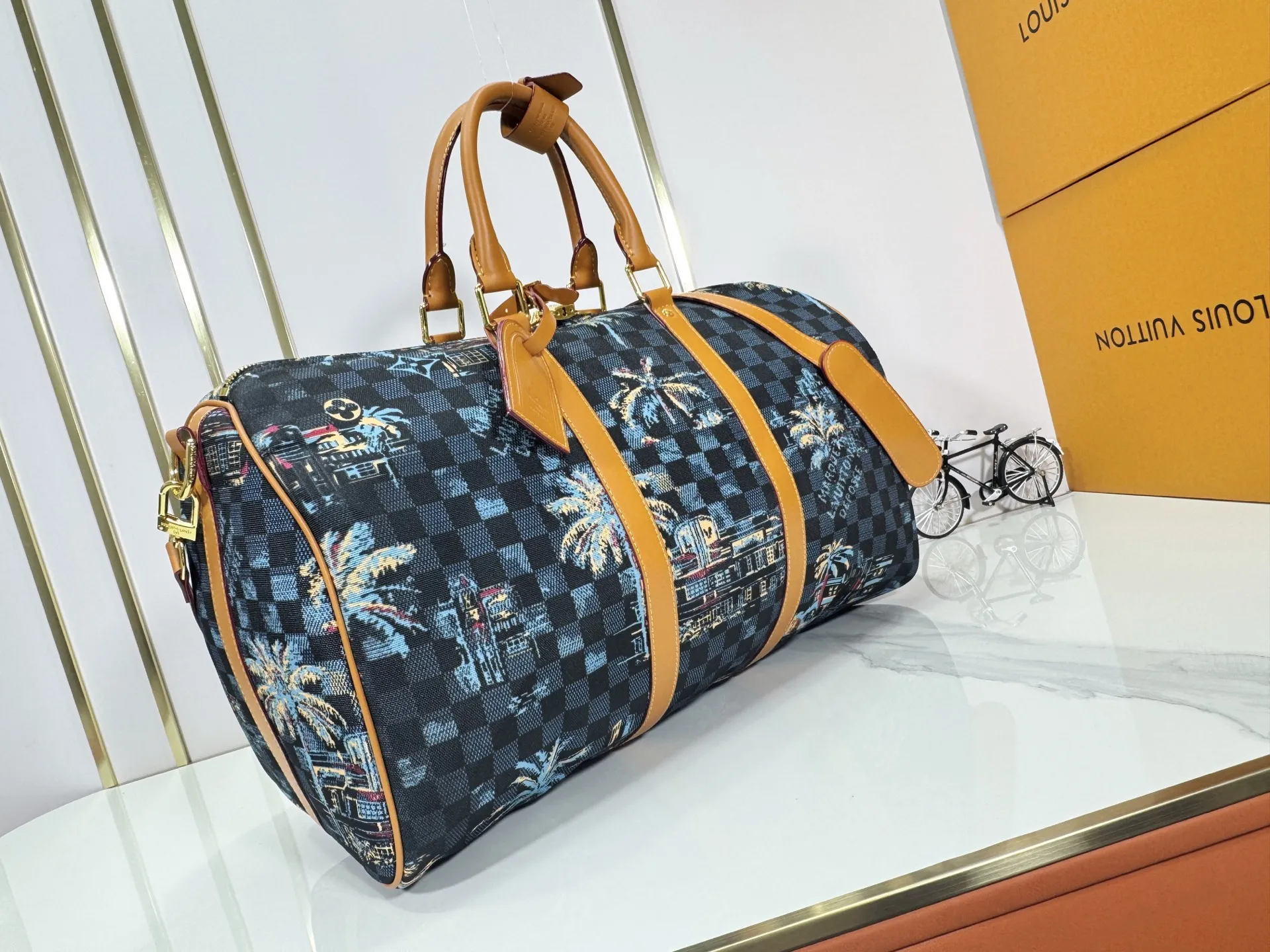 P360 Upgraded Original M00227 Coconut Tree This Keell Bandoulière 50 travel bag is made of gorgeous cotton with Damier lm Trees jacquard texture, showing the brand's exquisite craftsmanship. The checkerboard pattern highlights palm trees, iconic buildings and vintage car patterns, recalling the Miami night scene depicted in old postcards, and the Marque L.Vuitton Désée logo is subtly integrated into it.  29 x 23 x 50 cm (H x W x Length) Damier lm Trees Jacquard cotton Cow leather trim Fabric lining Metal hardware Carry-on baggage dimensions Double zipper closure Padlock Removable name tag Internal zippered pocket Shoulder straps: removable, adjustable Strap half-length: 36.0 cm Strap half-length adjustable to: 50.0 cm Handle: Double handle