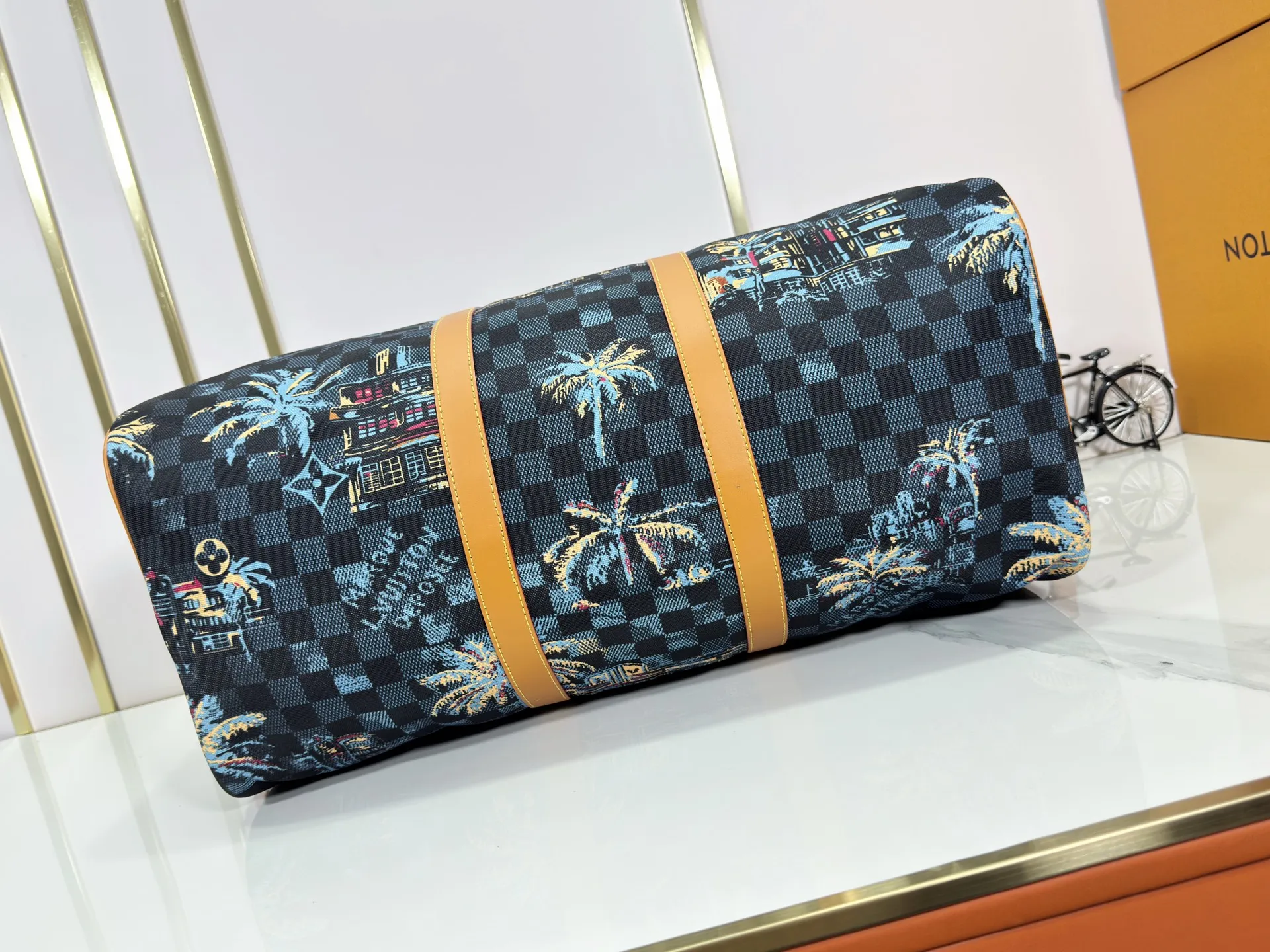 P360 Upgraded Original M00227 Coconut Tree This Keell Bandoulière 50 travel bag is made of gorgeous cotton with Damier lm Trees jacquard texture, showing the brand's exquisite craftsmanship. The checkerboard pattern highlights palm trees, iconic buildings and vintage car patterns, recalling the Miami night scene depicted in old postcards, and the Marque L.Vuitton Désée logo is subtly integrated into it.  29 x 23 x 50 cm (H x W x Length) Damier lm Trees Jacquard cotton Cow leather trim Fabric lining Metal hardware Carry-on baggage dimensions Double zipper closure Padlock Removable name tag Internal zippered pocket Shoulder straps: removable, adjustable Strap half-length: 36.0 cm Strap half-length adjustable to: 50.0 cm Handle: Double handle