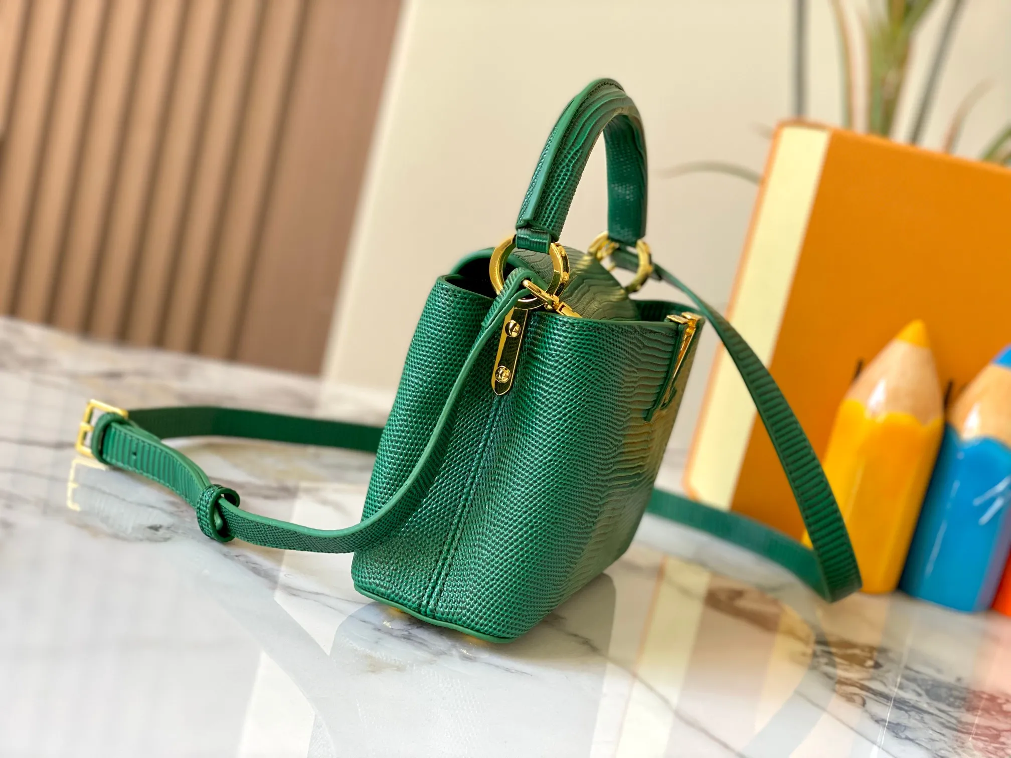 Top original P420 Guangzhou product M99527 green lizard gold buckle This Capucines mini handbag is wrapped in gorgeous lizard leather and lined with fine sheepskin, embellished with dazzling metal parts. The flip cover reads LV letters inside, and a Monogram flower blooms when turned out. Its compact size makes it a dazzling choice for evening occasions. Detailed features 21 x 14 x 8 cm (length x height x width)