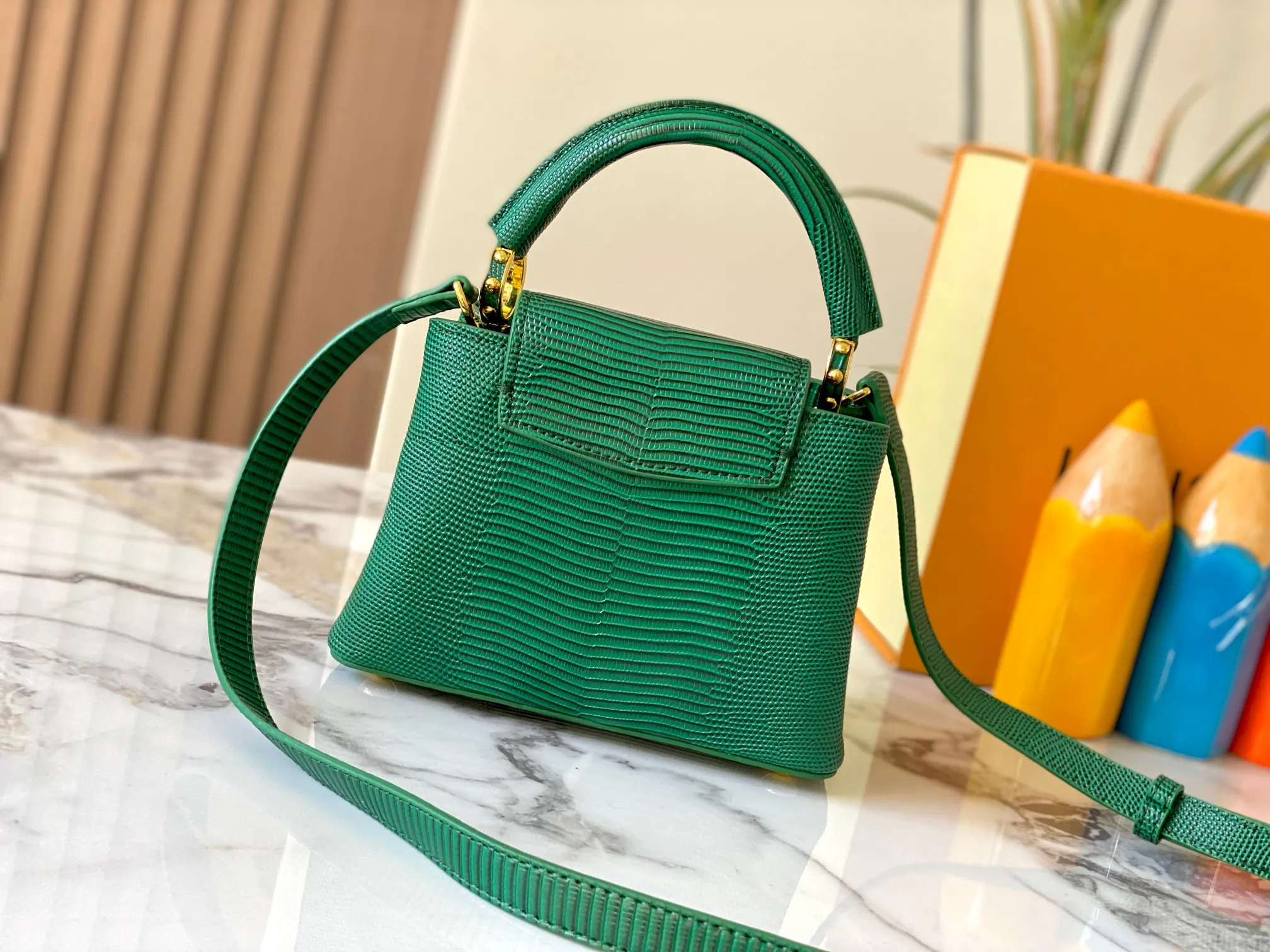 Top original P420 Guangzhou product M99527 green lizard gold buckle This Capucines mini handbag is wrapped in gorgeous lizard leather and lined with fine sheepskin, embellished with dazzling metal parts. The flip cover reads LV letters inside, and a Monogram flower blooms when turned out. Its compact size makes it a dazzling choice for evening occasions. Detailed features 21 x 14 x 8 cm (length x height x width)