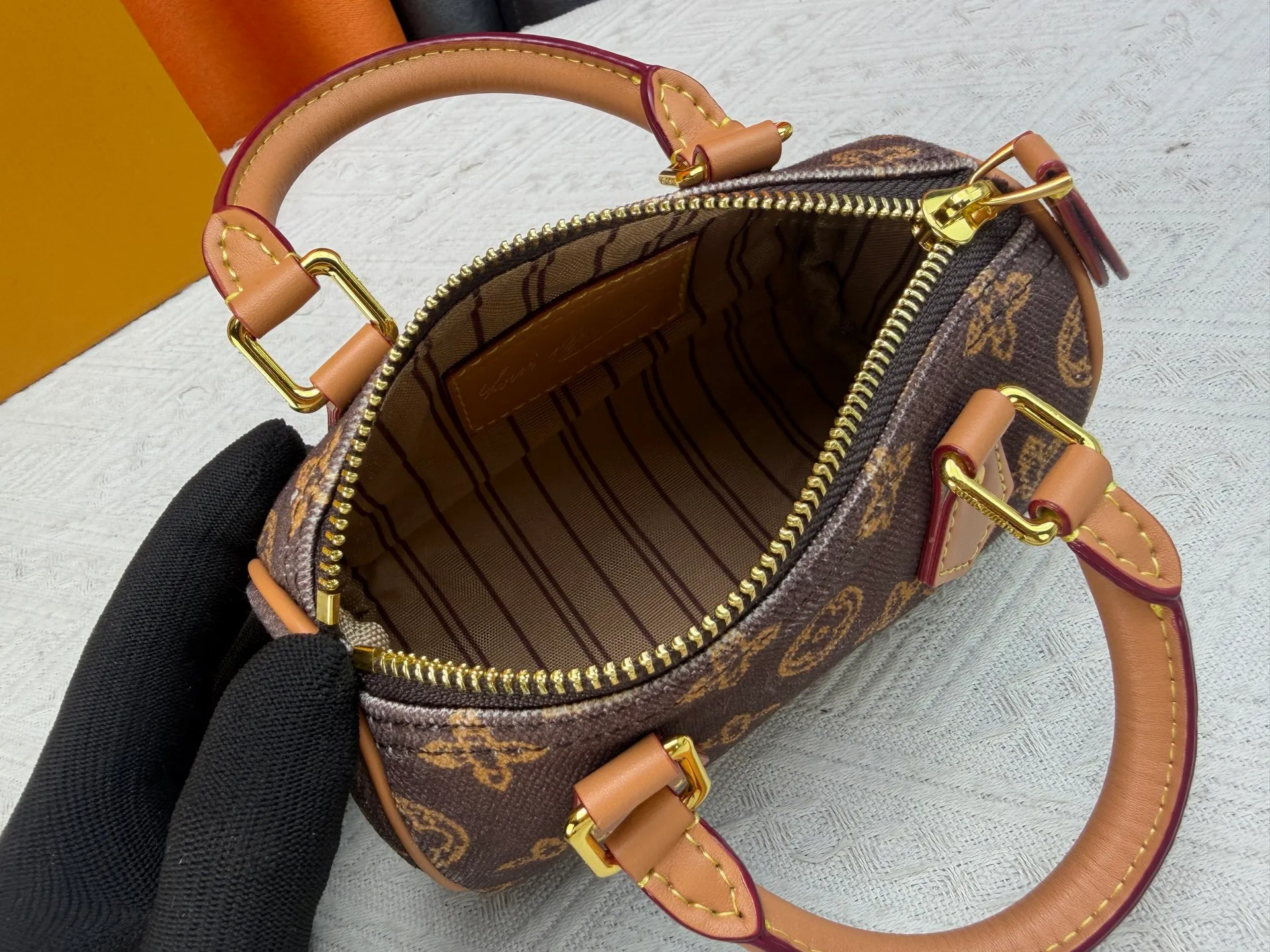 P220 M28322 Red M28323 M27610 M81085 [Exclusive background shot] This Nano Speedy handbag condenses the configuration of Louis Vuitton's classic Speedy handbag. It is made of Monogram canvas with distressed cow leather details and dazzling metal parts, making it easy to carry with you every day. The handles and removable and adjustable shoulder strap allow for a variety of styling possibilities. 16.0 x 10.0 x 7.5 cm (L x H x W) • Monogram coated canvas • Cow leather trim • Metal hardware • Zipper closure • Space to store daily necessities such as a 6.1-inch smartphone, card holder and lipstick • Shoulder strap: removable, adjustable • Half-length strap: 45.5 cm • Half-length strap adjustable to: 54.0 cm • Handle: Double handle
