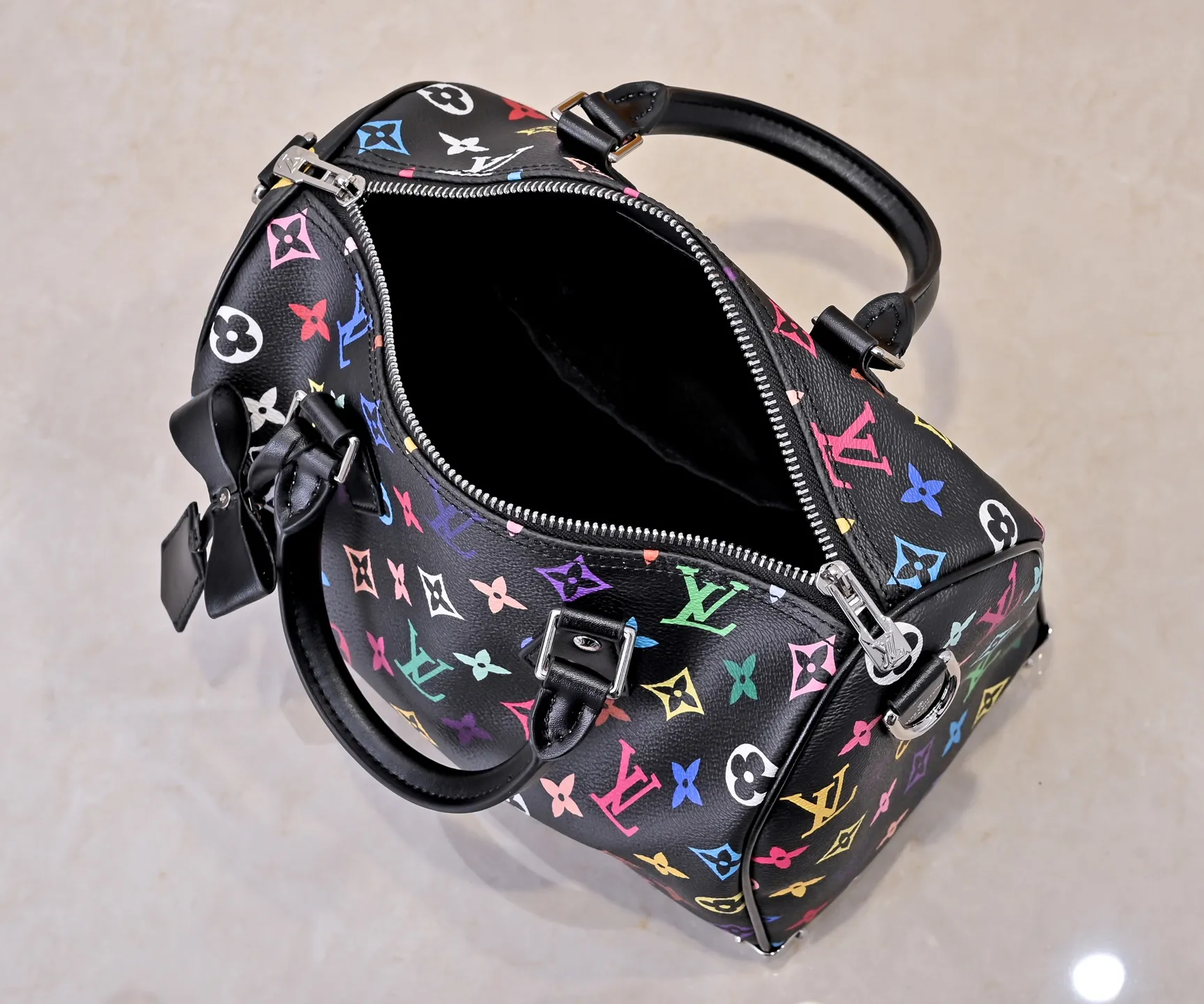 Batch 💰320 Guangzhou Product No.: M13085 40390 This Speedy Bandoulière 25 handbag uses the classic Monogram pattern to render the bright colors of Japanese artist Takashi Murakami. Together with the bow-shaped key bag, it highlights the smart style of the Louis Vuitton x Murakami collaboration series. The Toron handle and detachable and adjustable shoulder strap are fashioned from cow leather, and the dazzling padlock and corners reference the brand's luggage elements. 25 cm