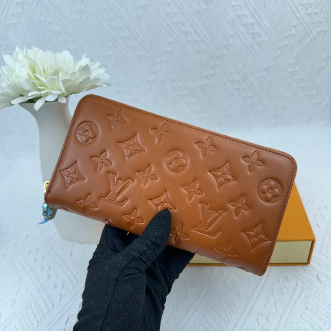 P130 M81511 Earthy Yellow Sewn with padded Monogram embossed lambskin, it complements the Coussin leather boutique series. Beautifully designed with a gold-tone zipper embossed with the LV Circle signature pull, the interior of the all-in-one wallet is packed with practical features, including three large compartments, a coin compartment and 12 business card slots. Dimensions: 19.5 x 10.5 x 2.5 cm