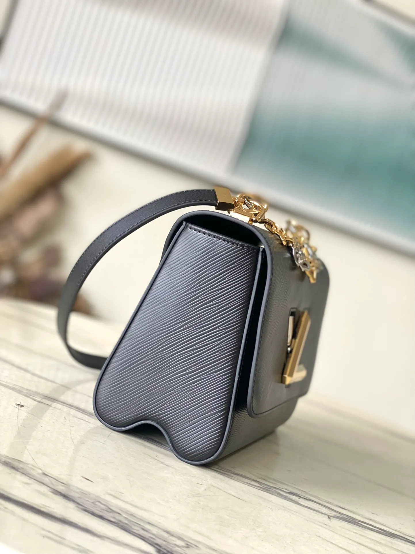 💰1160 (first-grain leather) top original order M22773 black water ripple Twist series TWIST medium handbag This Twist medium handbag exquisitely integrates the brand's iconic Monogram flower into the decorative chain, echoing the two-color lock, elegantly interpreting the Twisted Flowers theme of the season. One of the interior patch pockets has a removable mirror. Dimensions: 23 x 17 x 9.5 cm