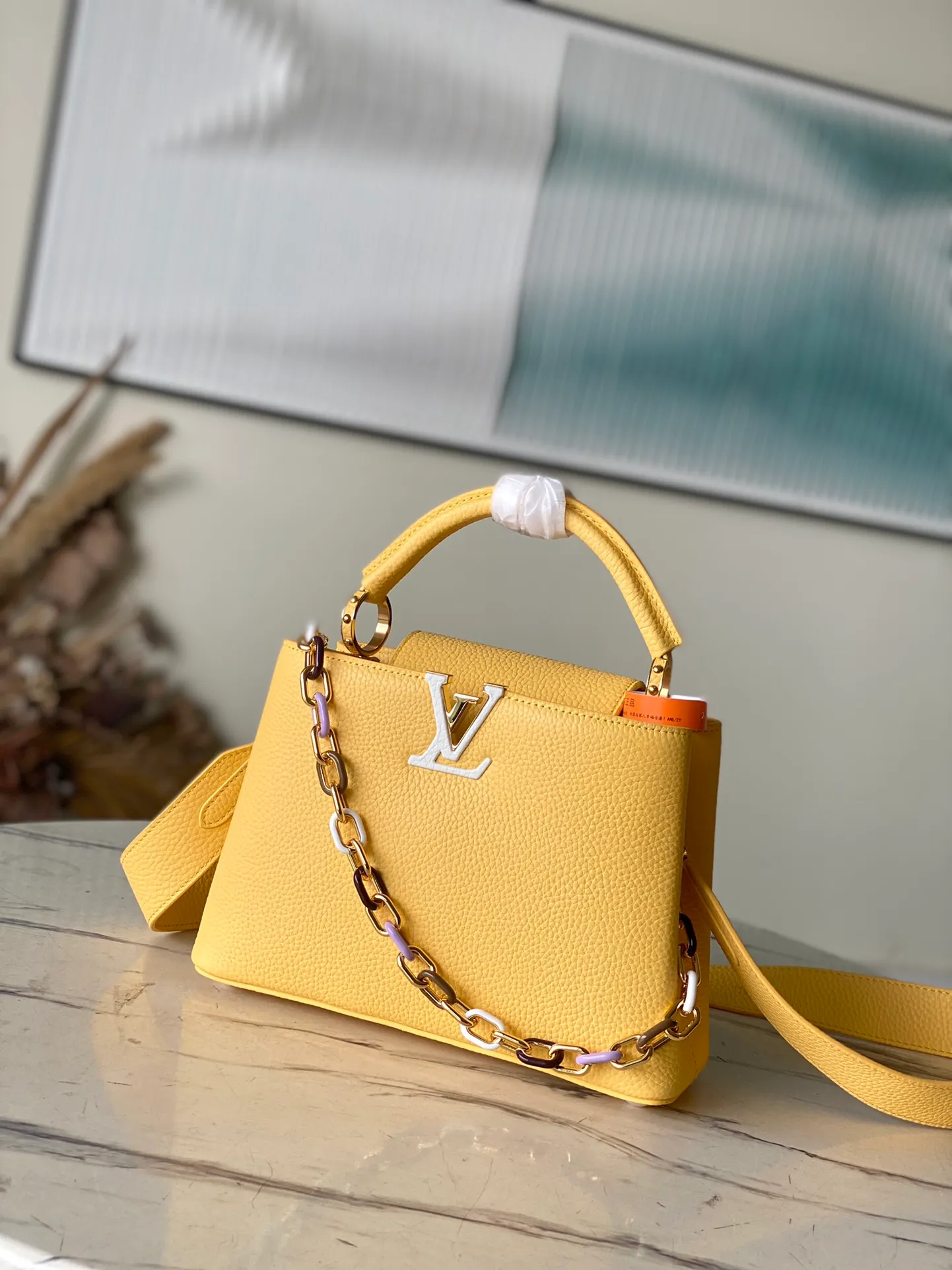 💰2660 (Special Grade Original Leather) M21798 Lemon Yellow Small This Capucines small handbag is made of Taurillon leather, with metal and resin links interlocking with each other, adding a fun carrying method in addition to the top handle and detachable wide shoulder strap. The signature flap of the Capucines collection is tucked in to reveal the logo. Dimensions: 27 x 18 x 9 cm