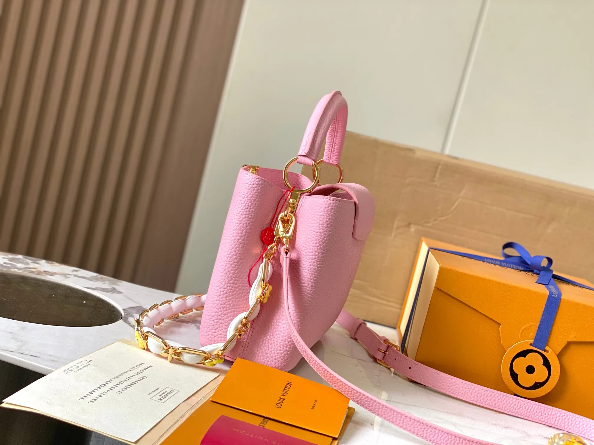 p2600 [Super high-quality original leather💋 M23280 pink and white shell buckle upgraded hardware] [Capucines BB handbag] This season’s new Capucines BB handbag highlights femininity. Metal links and elegant soft cow leather are woven into a delicate chain, with enamel and Monogram flowers scattered on it. The enamel brand logo highlights the texture of jewelry and makes the handbag even more beautiful.  Dimensions: 27 x 18 x 9 cm