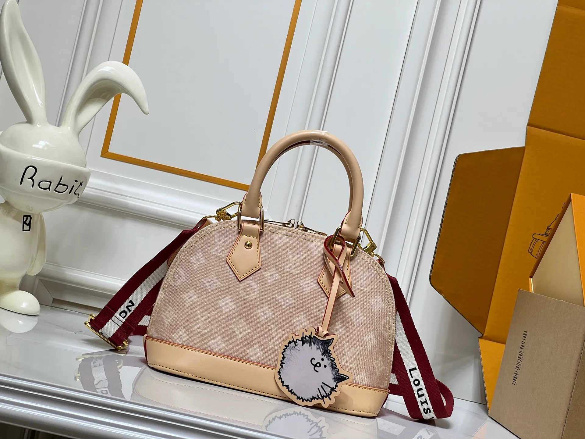 Batch 300💰Alma BB handbag M99021 M82348 A creative work of Louis Vuitton's Catogram series, the Alma BB handbag is made of light beige denim and engraved with the brand's iconic Monogram pattern, showing a retro style. Paired with beige leather trim and gold hardware, the classic shell bag shape incorporates cute cat charms, injecting vitality into the overall look. Equipped with a detachable shoulder strap, it can be carried by hand or cross-body to meet a variety of dressing needs. From daily outings to casual luxury socializing, it combines retro texture and cute design to become an eye-catching item that shows personality and taste. It is a fashionable choice for those who love cute style and classic design. Size: 23.5x17x11cm