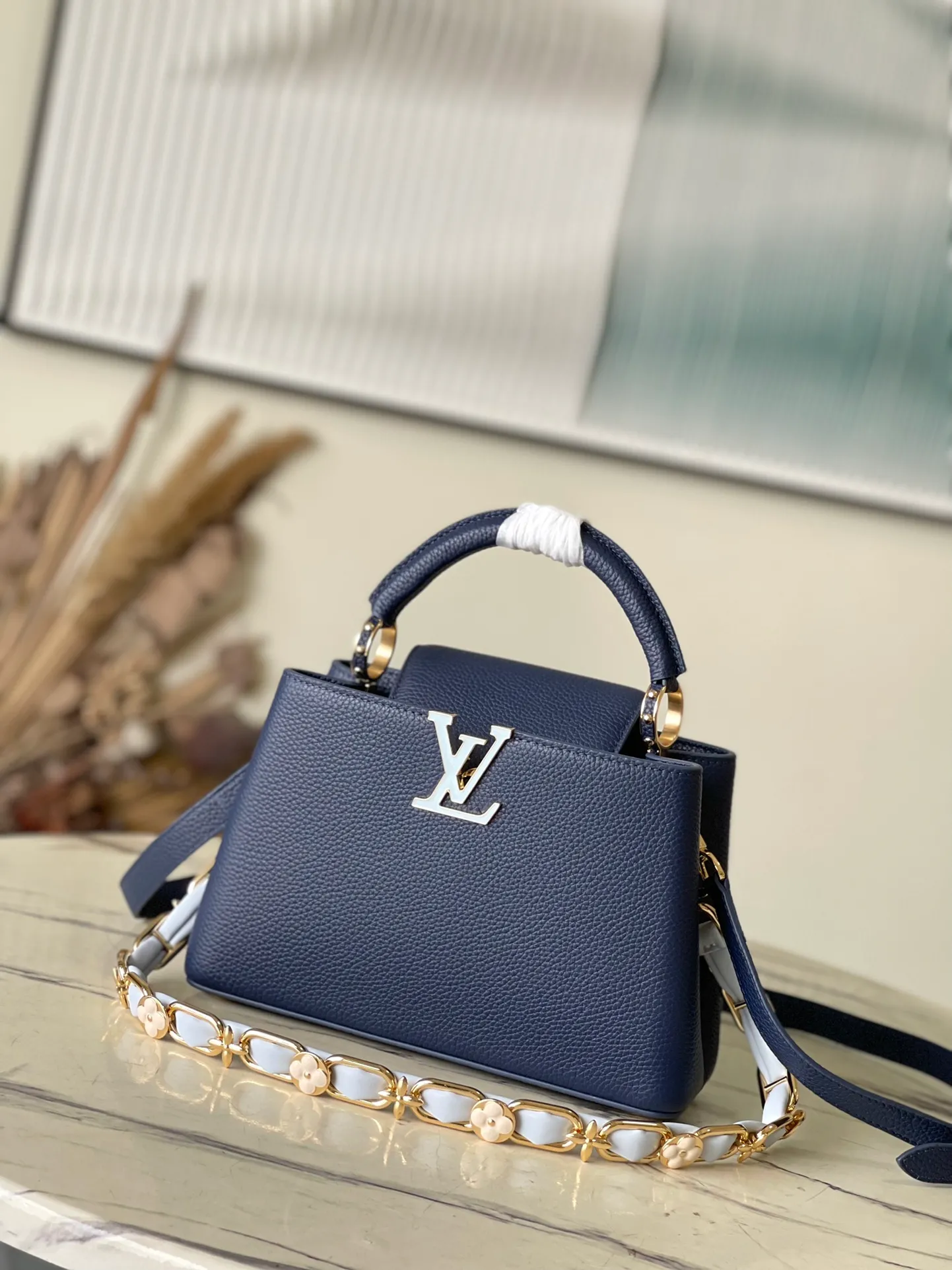 💰2400 (Special grade original leather) M23199 Blue Small This elegant Capucines small handbag combination is matched with a variety of materials and textures, made of aurilon leather, and equipped with a beautiful new version of Blossom Chain. Metal links and elegant soft cow leather are woven into a delicate chain, inlaid with Swiss enamel and veneer Monogram flowers. The colorful enamel brand logo highlights the texture of jewelry and makes the handbag even more beautiful. Dimensions: 27 × 18 × 9 cm