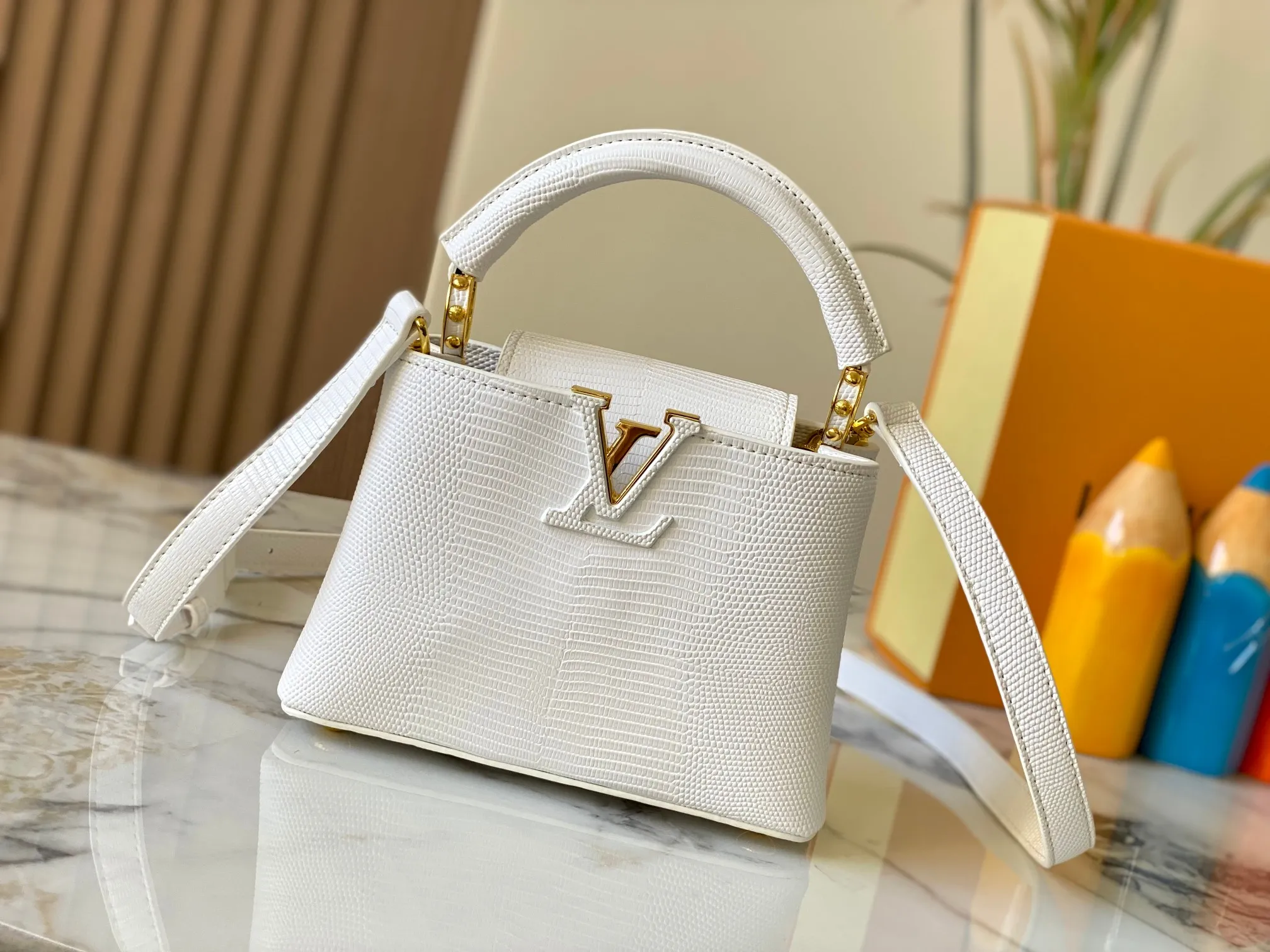Top original P420 Guangzhou product M99527 white lizard gold buckle This Capucines mini handbag is wrapped in gorgeous lizard leather and lined with fine sheepskin, embellished with dazzling metal parts. The flip cover reads LV letters inside, and a Monogram flower blooms when turned out. Its compact size makes it a dazzling choice for evening occasions. Detailed features 21 x 14 x 8 cm (length x height x width)