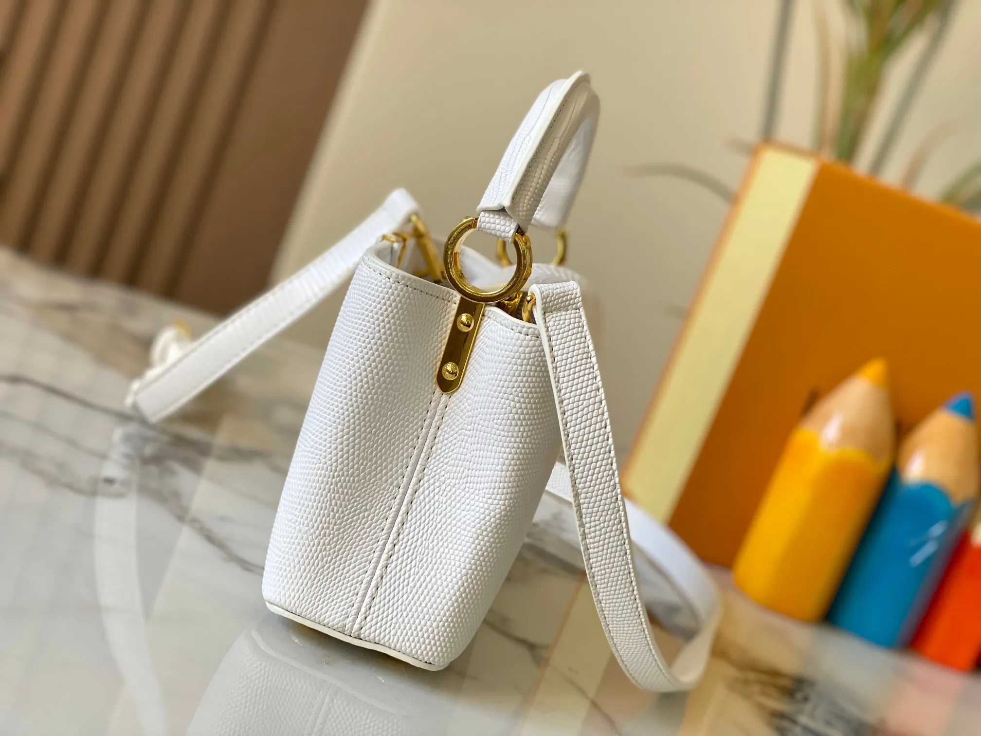 Top original P420 Guangzhou product M99527 white lizard gold buckle This Capucines mini handbag is wrapped in gorgeous lizard leather and lined with fine sheepskin, embellished with dazzling metal parts. The flip cover reads LV letters inside, and a Monogram flower blooms when turned out. Its compact size makes it a dazzling choice for evening occasions. Detailed features 21 x 14 x 8 cm (length x height x width)