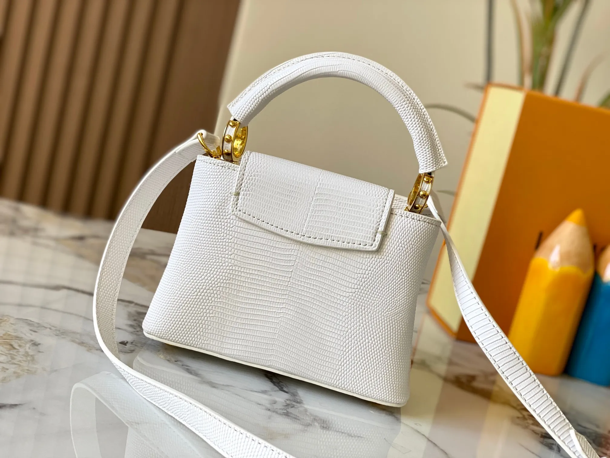 Top original P420 Guangzhou product M99527 white lizard gold buckle This Capucines mini handbag is wrapped in gorgeous lizard leather and lined with fine sheepskin, embellished with dazzling metal parts. The flip cover reads LV letters inside, and a Monogram flower blooms when turned out. Its compact size makes it a dazzling choice for evening occasions. Detailed features 21 x 14 x 8 cm (length x height x width)