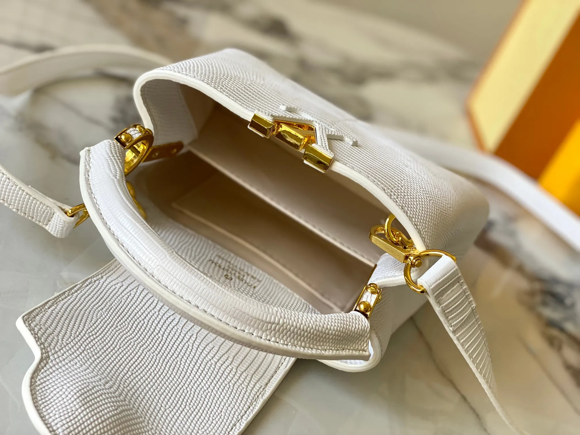 Top original P420 Guangzhou product M99527 white lizard gold buckle This Capucines mini handbag is wrapped in gorgeous lizard leather and lined with fine sheepskin, embellished with dazzling metal parts. The flip cover reads LV letters inside, and a Monogram flower blooms when turned out. Its compact size makes it a dazzling choice for evening occasions. Detailed features 21 x 14 x 8 cm (length x height x width)