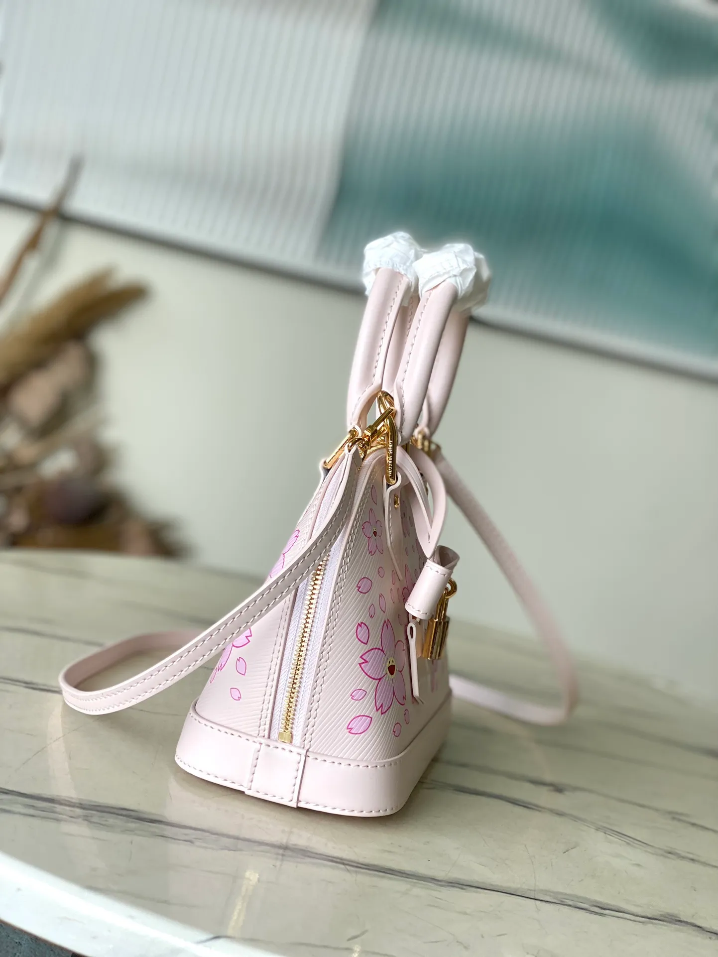 💰1400 Top original order M13104 (M40302 Sakura) Maison’s iconic Alma BB bag is now modified into a playful cherry blossom pattern, which is the creation of artist Takashi Murakami, symbolizing innovation. The design is sewn from Epi leather, veined in an elegant pink color, combined with shiny yellow metallic details. There is room inside to enlarge daily necessities such as mobile phones. Toron handles and an easily removable leather strap complete the overall luxury feel.  23.5 x 17.5 x 11.5 cm (LxHxW)