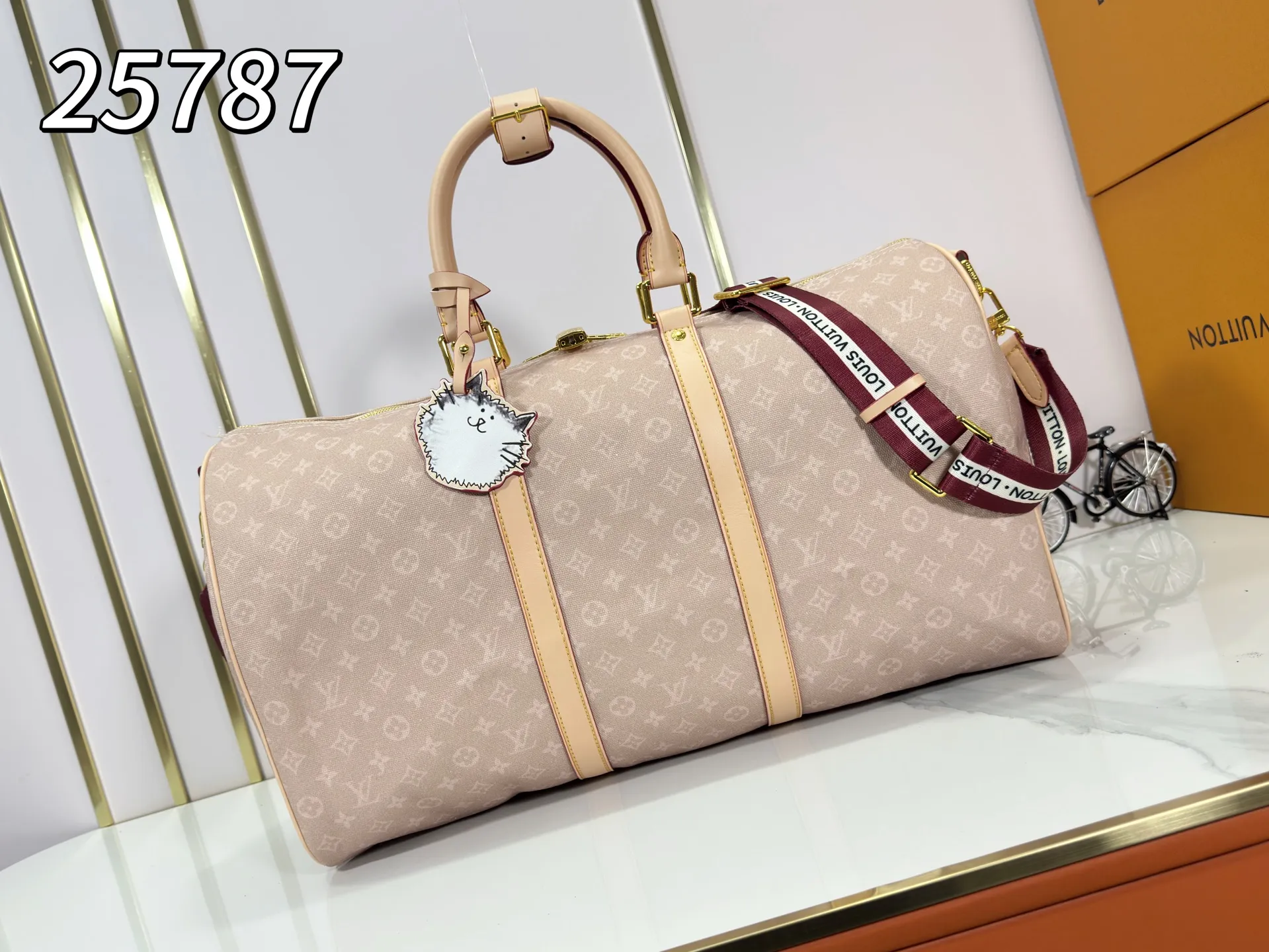 P360 M25787 M41416 This Keepall Bandouliere 50 travel bag is from the Travel With series presented by Louis Vuitton in collaboration with Grace Coddington. It uses Meowgram canvas to interpret the Monogram pattern in a playful way, looking back to the hard suitcase inspiration of the 1900s. The cute cat-shaped branding adds smart touches, and the detachable and adjustable shoulder strap is embellished with the handwritten brand logo. Size: 50x29x23cm