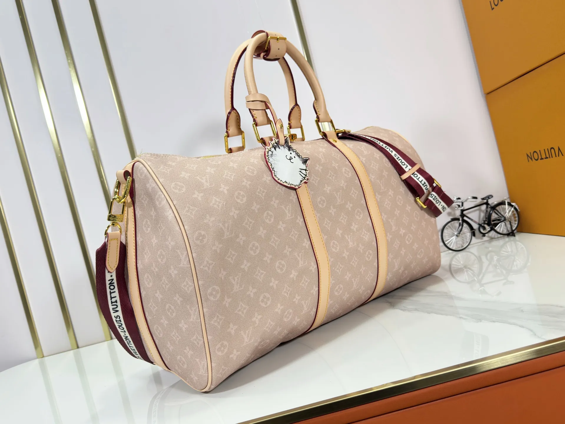 P360 M25787 M41416 This Keepall Bandouliere 50 travel bag is from the Travel With series presented by Louis Vuitton in collaboration with Grace Coddington. It uses Meowgram canvas to interpret the Monogram pattern in a playful way, looking back to the hard suitcase inspiration of the 1900s. The cute cat-shaped branding adds smart touches, and the detachable and adjustable shoulder strap is embellished with the handwritten brand logo. Size: 50x29x23cm