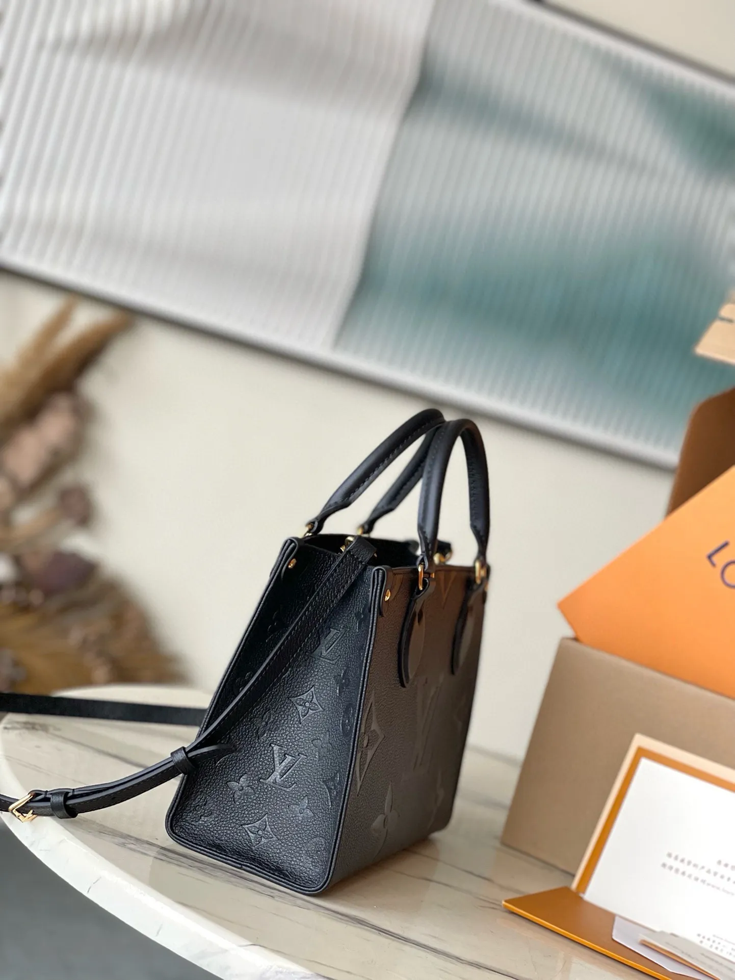 💰1040 (first-grain leather) top original M45653 black printed Onthego small Tote bag draws inspiration from the classic Sac Plat handbag in 1968. It is made of Monogram Empreinte leather with Medium Bicolor Monogram pattern embossed to create a miniature version, which can store daily needs such as iPad Mini. Flexible handles and detachable shoulder strap enrich carrying options. Dimensions: 25 x 19 x 11.5 cm