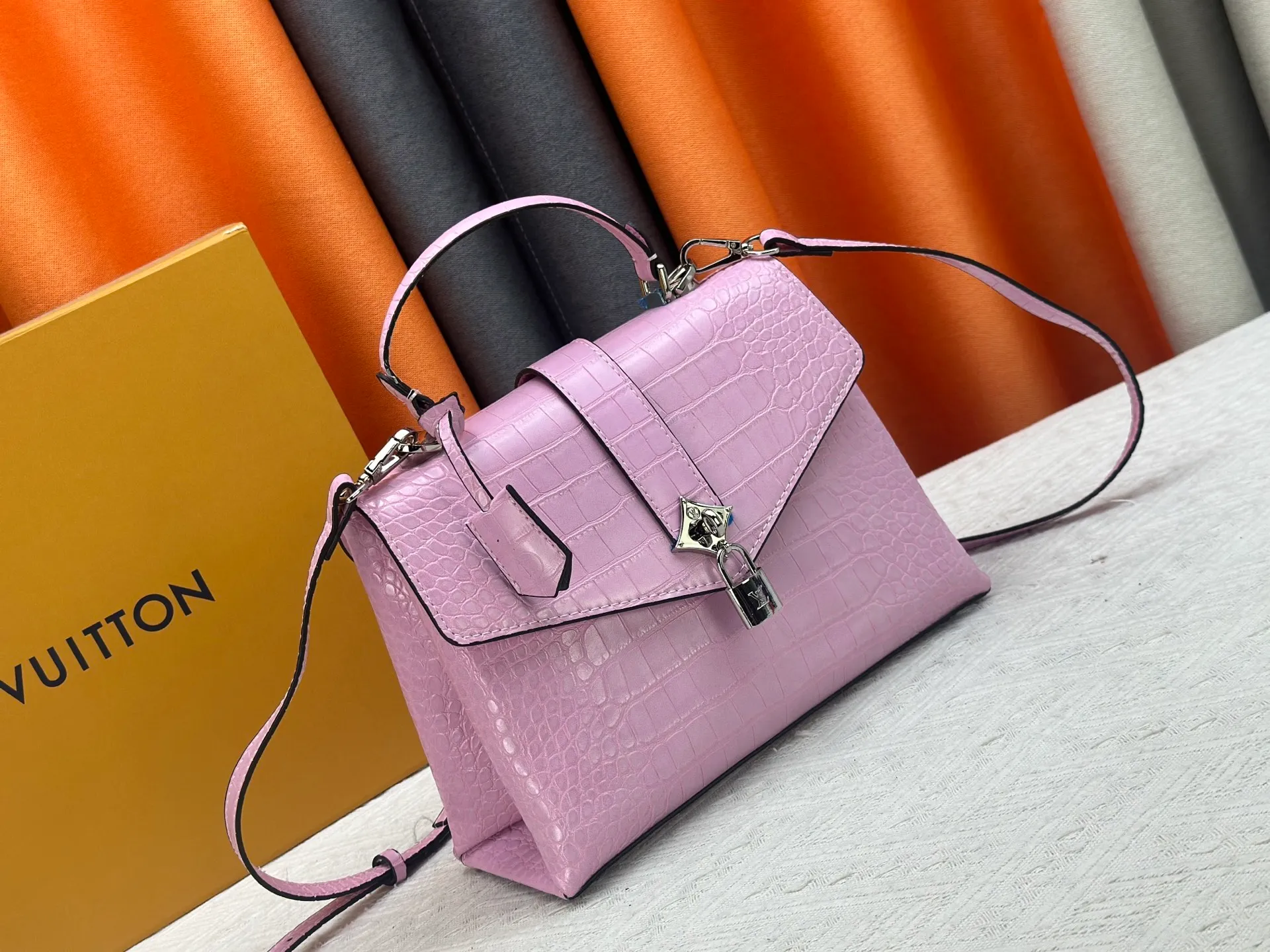 P300 M80527 N82033.N98925 Crocodile black N98928.N80432 Crocodile pink N99017 Crocodile gray N84714 Himalayan N86012 black with crocodile Rose des Vents small handbag is made of smooth and grained calfskin to outline elegant lines, embellished with golden LV padlocks to shine. Clever use of the top handle and detachable and adjustable shoulder strap create an elegant elbow or practical cross-body style for everyday travel. Medium size Length 27 Width 11 Height 19