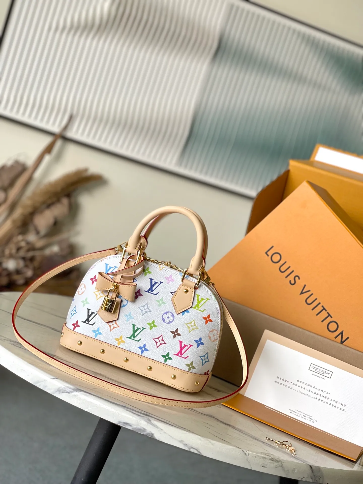 💰1080 Top original order M13078 This AmaBB handbag is filled with the joyful style of the Louis Vuitton x Murakami collaboration series, cleverly recalling the Art Deco style design of the 1930s. Monogram coated canvas is dyed in Murakami’s playful tones, and classic cow leather elements are incorporated into the Toron handle, bag base, detachable shoulder strap and LVxTM key bag. Dimensions: 23.5 × 17.5 × 11.5 cm