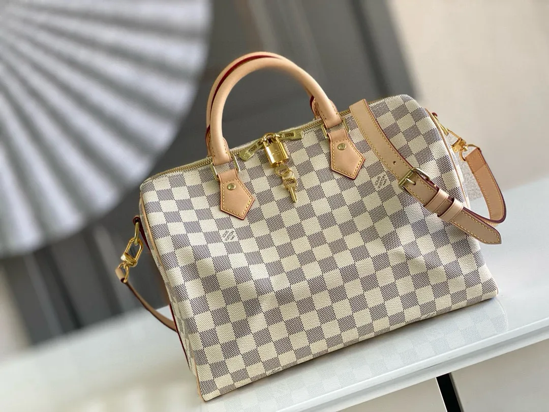 💰800 Top original N41373 SPEEDY 30 handbag (with shoulder strap) Every feature of this Speedy handbag is classic: leather handle, Damier Azur canvas. No wonder it has become a particularly popular bag in the world. Originally designed for travelers in 1930 (its name pays homage to the high-speed traffic of the time), the Speedy 30, with its cross-body strap, has become the ideal urban bag - soft, lightweight and classic. Detailed Features 30 x 21 x 17 cm (Length x Height x Width) Shiny gold-tone brass hardware and padlock Lockable double zipper closure Internal pocket D-ring for keys and accessories Soft fabric lining Shoulder strap: removable, adjustable Strap half-length: 48.0 cm Strap half-length adjustable to: 55.0 cm Handle: Double handle
