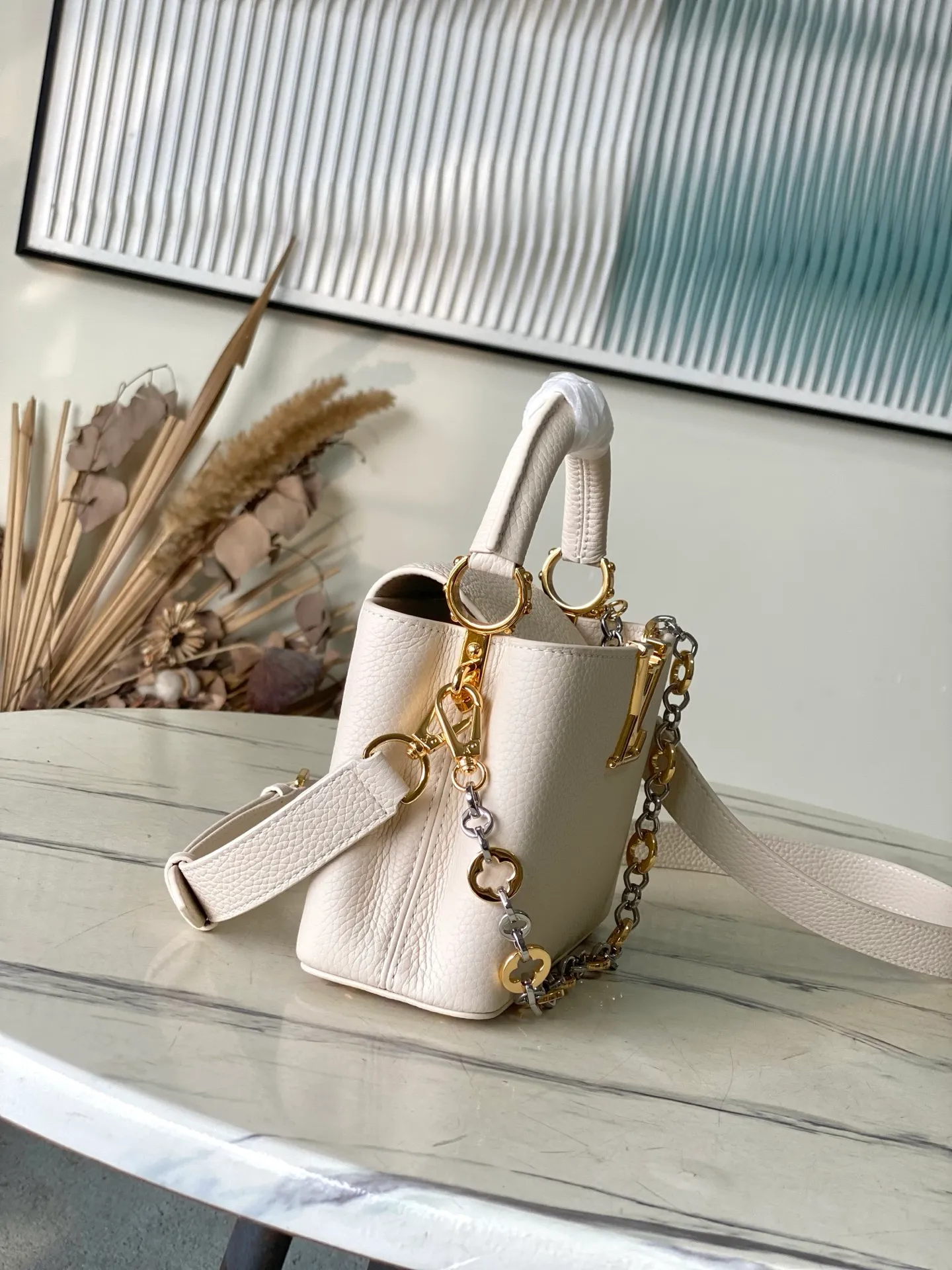 💰2180 "Special Grade Original Leather" M12935 Milky White Mini This Capucines mini handbag is made of flexible Taurillon cow leather. It uses jewelry-style double-plated chains and Monogram floral elements to highlight the identity of the Chain On You series. The flip cover can be placed on both the inside and outside. The ample structure and multiple inner pockets are convenient for storing daily needs. The rounded V letter adds an ingenious detail. Dimensions: 21 × 13.6 × 8 cm
