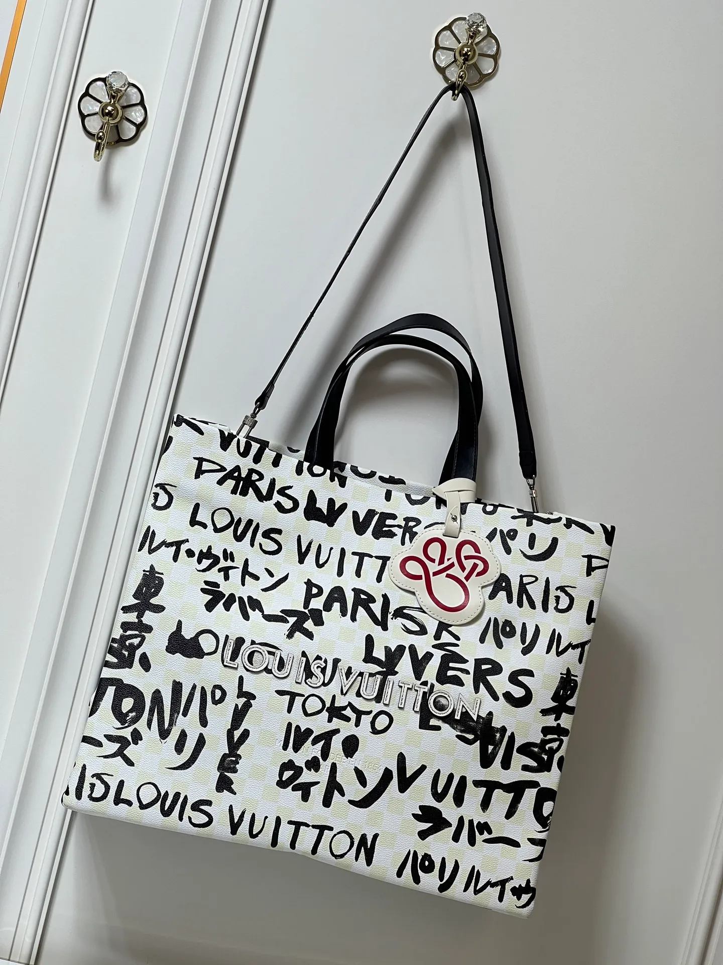 Batch 320💰M24457 M40797 This Shopper Tote medium handbag features Damier checkerboard pattern superimposed with eye-catching hand-painted elements, witnessing the joint creativity of Pharrell Williams and Japanese designer Nigo. The names Louis Vuitton, Paris and Tokyo, as well as the word Lvvers, are bilingual in French and Japanese, and the graphic cotton lining showcases Nigo's signature style. Size: 41x34x16cm
