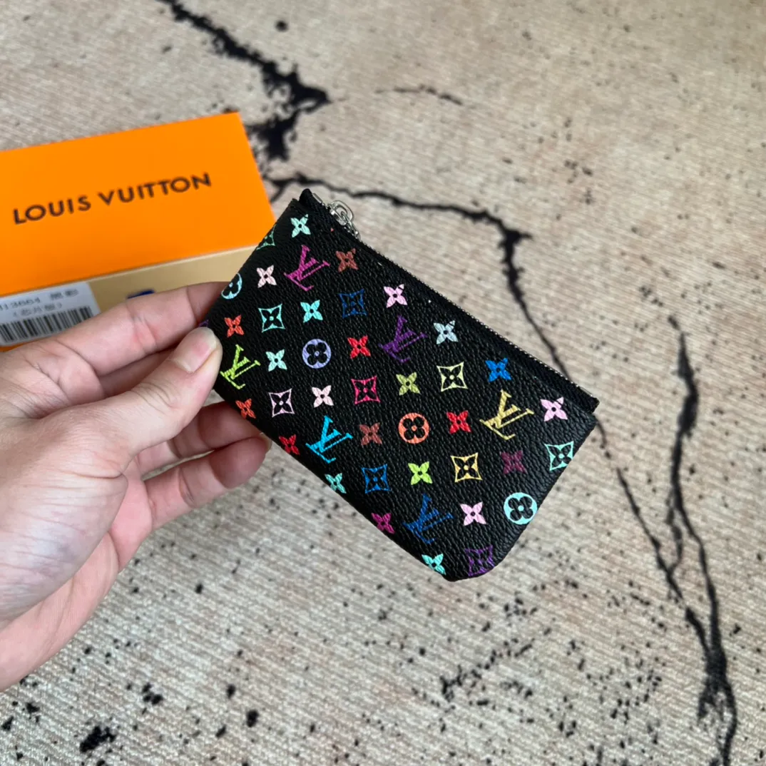 Factory price 280 Top original order M13664 black color This replica Louis Vuitton x Murakami series key coin purse is colorful and made of coated canvas. The vibrant iconic Monogram pattern reinterprets the brand logo with the theme of Japanese artist Takashi Murakami in rainbow tones. The key coin purse has a silver zipper and is equipped with a chain strap and hook buckle to store keys securely. 12 x 7 x 1.5 cm (length x height x width)