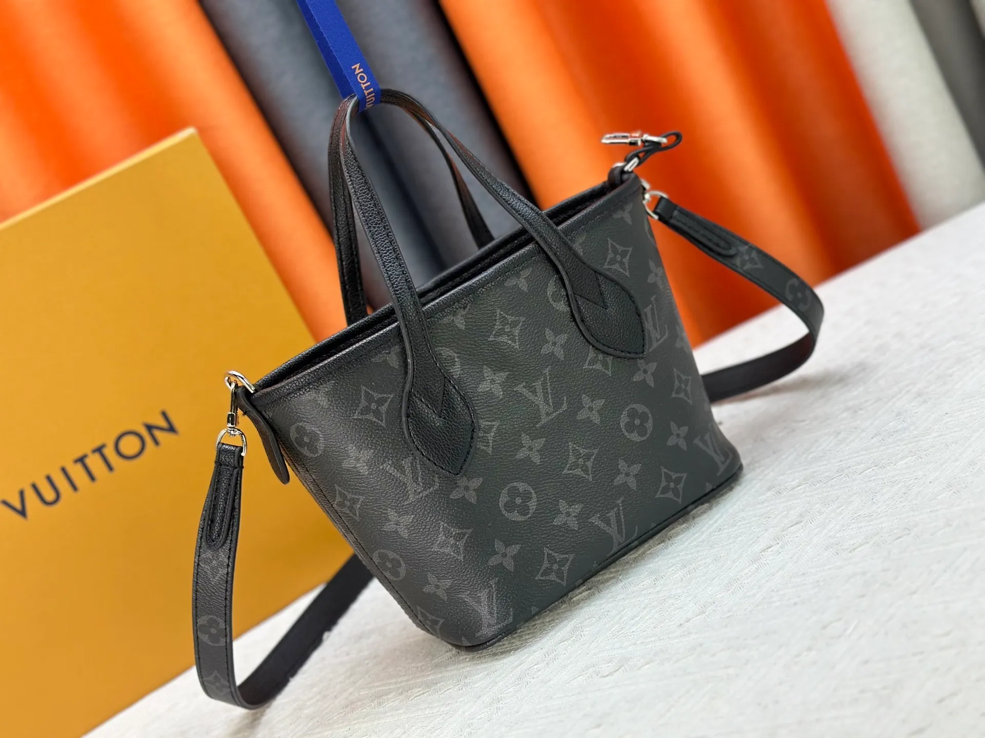 P240 M25656 M12099 Upgraded original Neverfull Bandouliere Inside Out BB handbag is a double-sided version of the classic design this season, with the front and back decorated with iconic Monogram canvas and grained leather. The removable zipper bag can be used alone or hung externally. The detachable shoulder strap makes it easy to wear cross-body, and the dazzling metal hardware adds a sophisticated detail. Dimensions: 26.5 × 16.5 × 11 cm