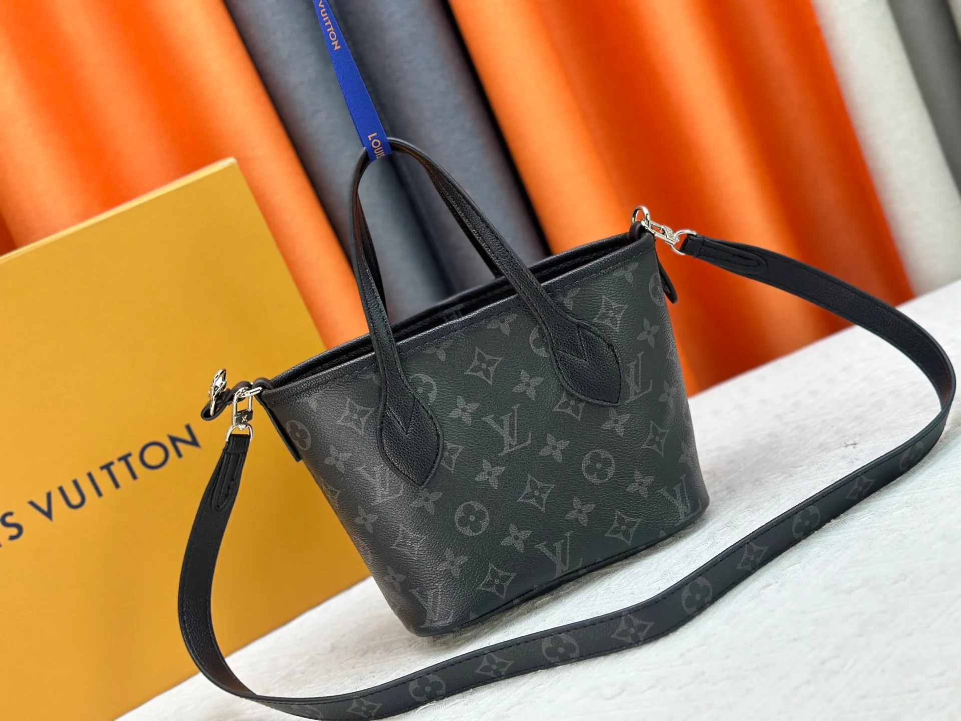 P240 M25656 M12099 Upgraded original Neverfull Bandouliere Inside Out BB handbag is a double-sided version of the classic design this season, with the front and back decorated with iconic Monogram canvas and grained leather. The removable zipper bag can be used alone or hung externally. The detachable shoulder strap makes it easy to wear cross-body, and the dazzling metal hardware adds a sophisticated detail. Dimensions: 26.5 × 16.5 × 11 cm