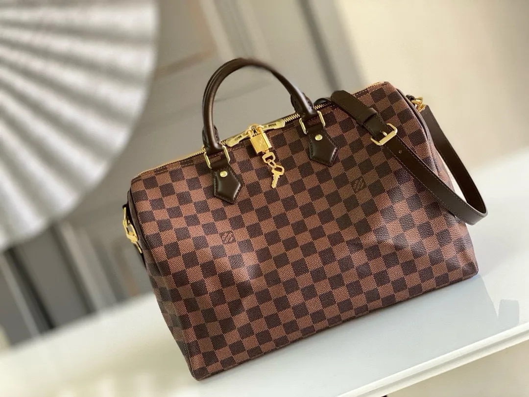 💰840 (size 35) Top original N41366 SPEEDY 35 handbag (with shoulder strap) The Speedy 35 handbag made of Damier Ebène canvas has a classic shape and exudes timeless elegance. The multifunctional shoulder strap can be used to carry it by hand, on the shoulder or across the body, making it flexible and convenient. Detailed features 35 x 23 x 18 cm (Length x Height x Width) Smooth leather trim Shiny gold-tone brass hardware Double zip closure with padlock Internal pocket D-ring for keys and accessories Soft fabric lining Shoulder strap: Removable, adjustable Half-length strap: 47.0 cm Half-length strap adjustable to: 53.5 cm Handle: Double handle