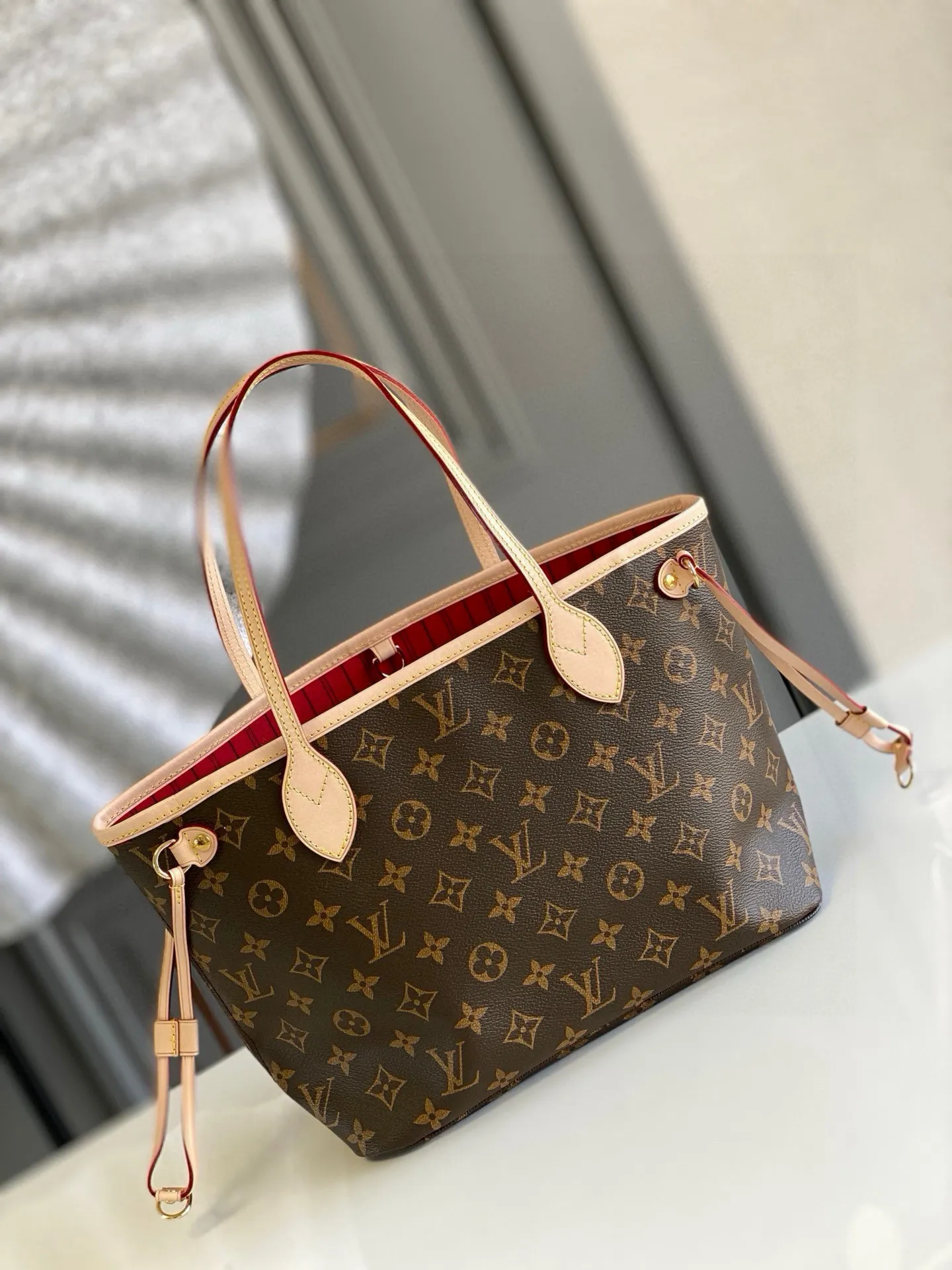 💰780 (Small Steel Nail) Top Original M41000 Red NEVERFULL PM This Neverfull MM handbag combines timeless classic design with traditional details. It is made of Monogram canvas and trimmed with natural cowhide. The interior is extra spacious but not heavy. Tighten the side straps to create a fashionable and charming shape, and loosen them to show a more casual atmosphere. The slim and comfortable handle can be easily slung over the shoulder or carried by arm. Lined in a vibrant color, the bag has a detachable organizer that can be used independently as a clutch or as an extra pocket. 29 cm