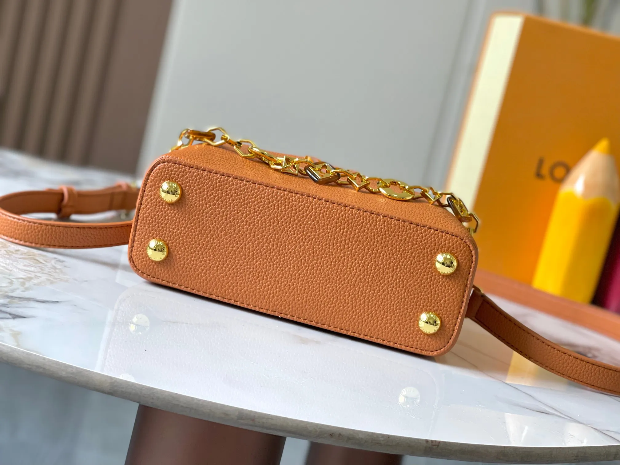p460 [Guangzhou top quality original] M14393 brown CapucinesEastWest mini handbag, using a decorative chain to show the inspiration of Monogram flowers. Taurillon cow leather creates an exquisite structure, and the LV letters interpret the colorful brushstrokes of the Puffygram jewelry series. The flap can be folded in or out, and the inner pocket can safely store valuables. Size:22×12×8cm