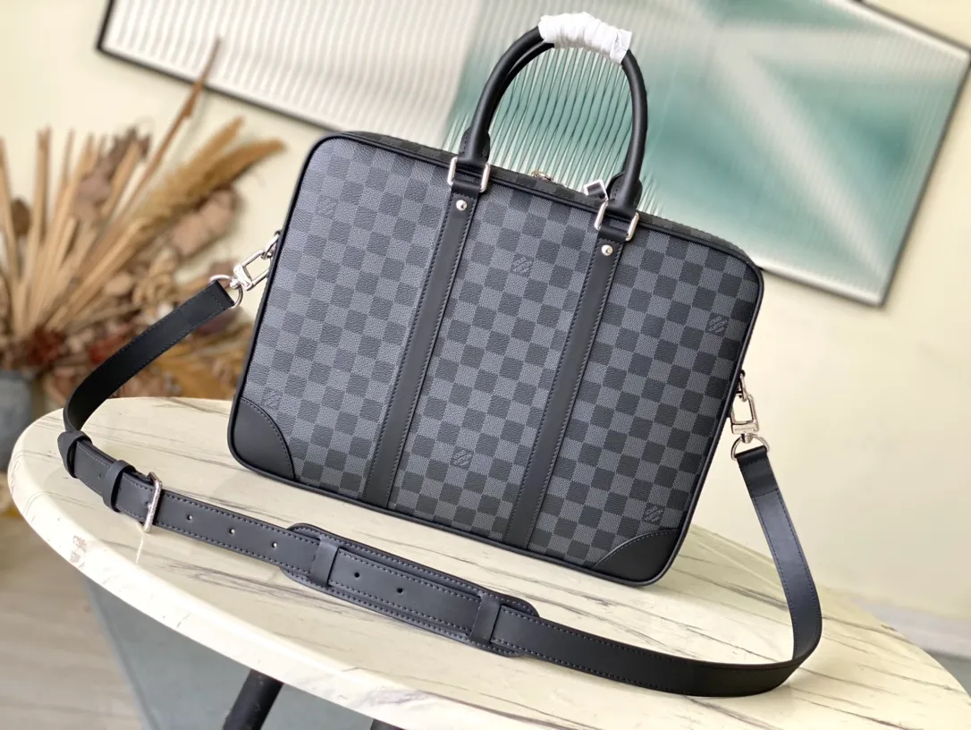 💰1100 Top original order N40485 Voyage large briefcase is a space upgrade on the classic Attache briefcase. Damier Graphite canvas body with cowhide leather trim, extra side straps and top handles. A padded interior compartment holds a laptop, and dual patch pockets and zip pockets add functionality. Dimensions: 39.5 × 29 × 9 cm