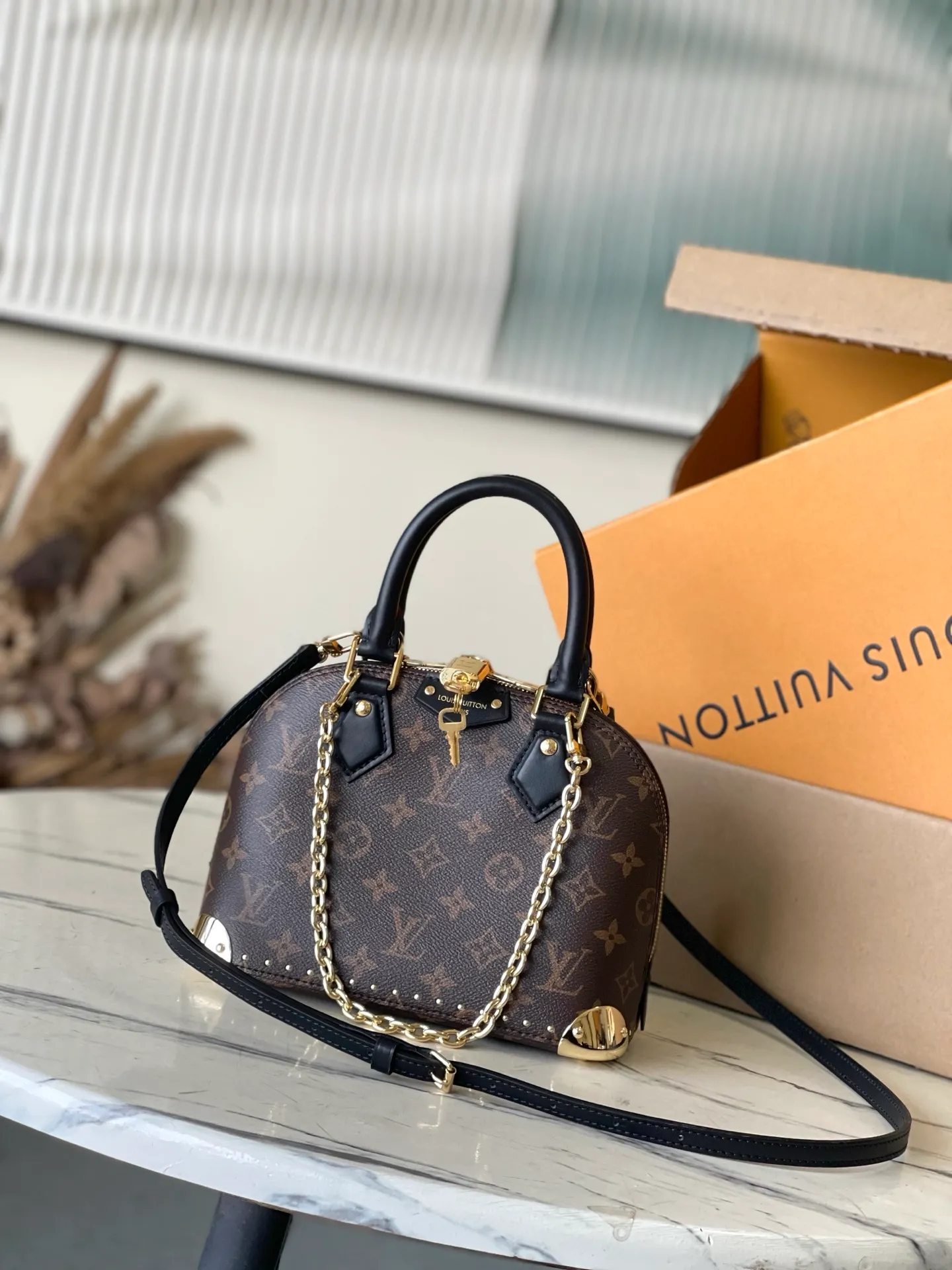 💰1020 The top original M26084 AlmaBB handbag has been reinterpreted and becomes a new member of the Trunk series, paying tribute to the brand's long travel culture with its classic logo. The handbag is made of Monogram canvas, trimmed with deep leather, and embellished with dazzling metal corners and studs. This version comes with a removable chain that can be worn with the adjustable shoulder strap or alone. Dimensions: 22 × 19 × 11 cm