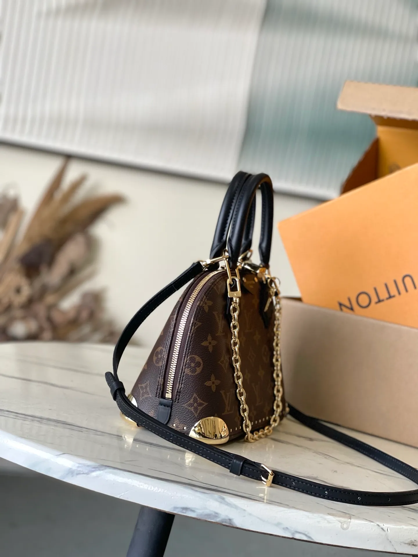 💰1020 The top original M26084 AlmaBB handbag has been reinterpreted and becomes a new member of the Trunk series, paying tribute to the brand's long travel culture with its classic logo. The handbag is made of Monogram canvas, trimmed with deep leather, and embellished with dazzling metal corners and studs. This version comes with a removable chain that can be worn with the adjustable shoulder strap or alone. Dimensions: 22 × 19 × 11 cm