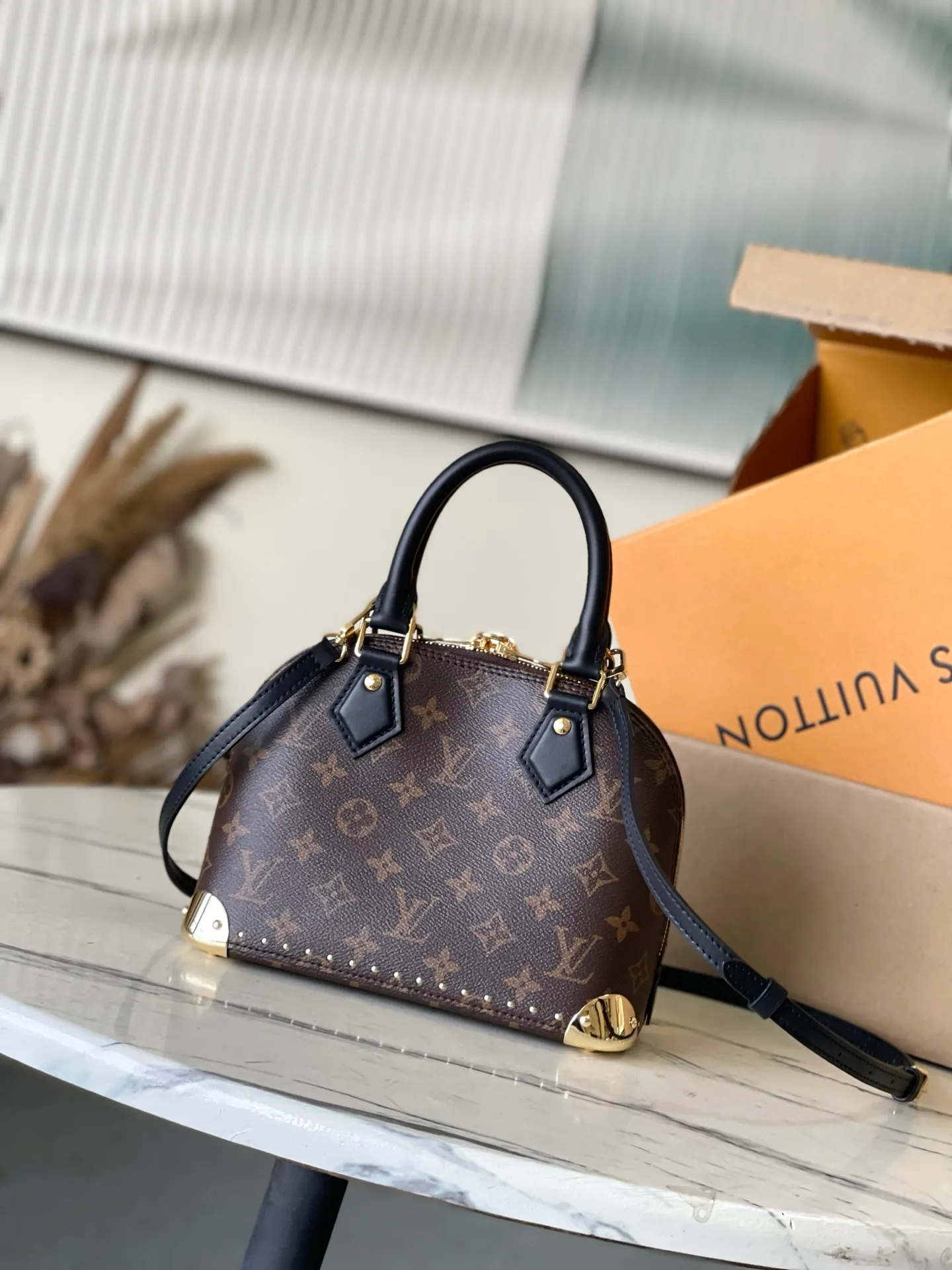 💰1020 The top original M26084 AlmaBB handbag has been reinterpreted and becomes a new member of the Trunk series, paying tribute to the brand's long travel culture with its classic logo. The handbag is made of Monogram canvas, trimmed with deep leather, and embellished with dazzling metal corners and studs. This version comes with a removable chain that can be worn with the adjustable shoulder strap or alone. Dimensions: 22 × 19 × 11 cm