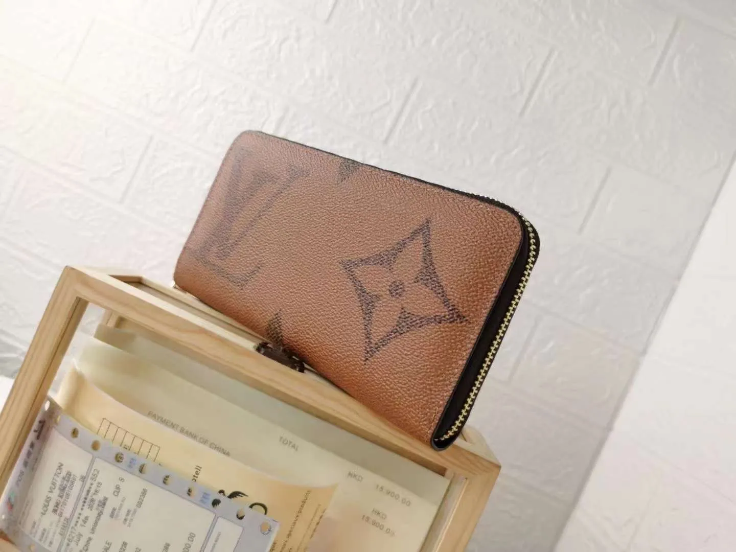 P140M60017 Light Brown Large Characters Dark Brown Large Characters ZIppy Zipper Wallet Printed canvas zipper coin purse, the large LV letters and Monogram floral pattern are particularly eye-catching. The compact zipper wallet is one of the classic designs. This wallet can hold banknotes, credit cards, small change, IDs, etc. Size 19x10cm.