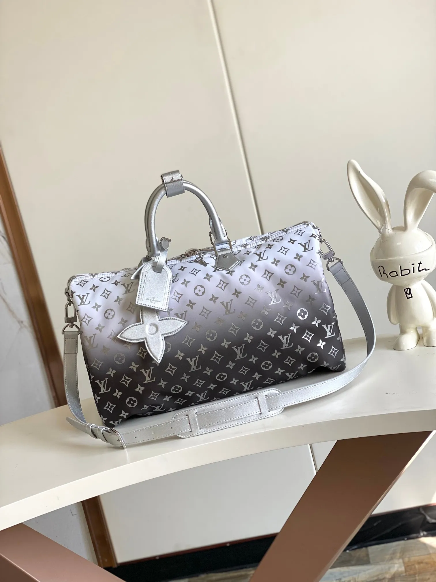 💰1260 Top original single dynamic chip M12067 silver This Keepall Bandoulière 45 travel bag is made of gradient effect Monogram nylon, with plain leather Monogram flower decoration to set off the winter mood. Durable and soft recycled nylon creates a close-fitting design, and the detachable leather strap allows for easy shoulder or cross-body wear.  27 cm