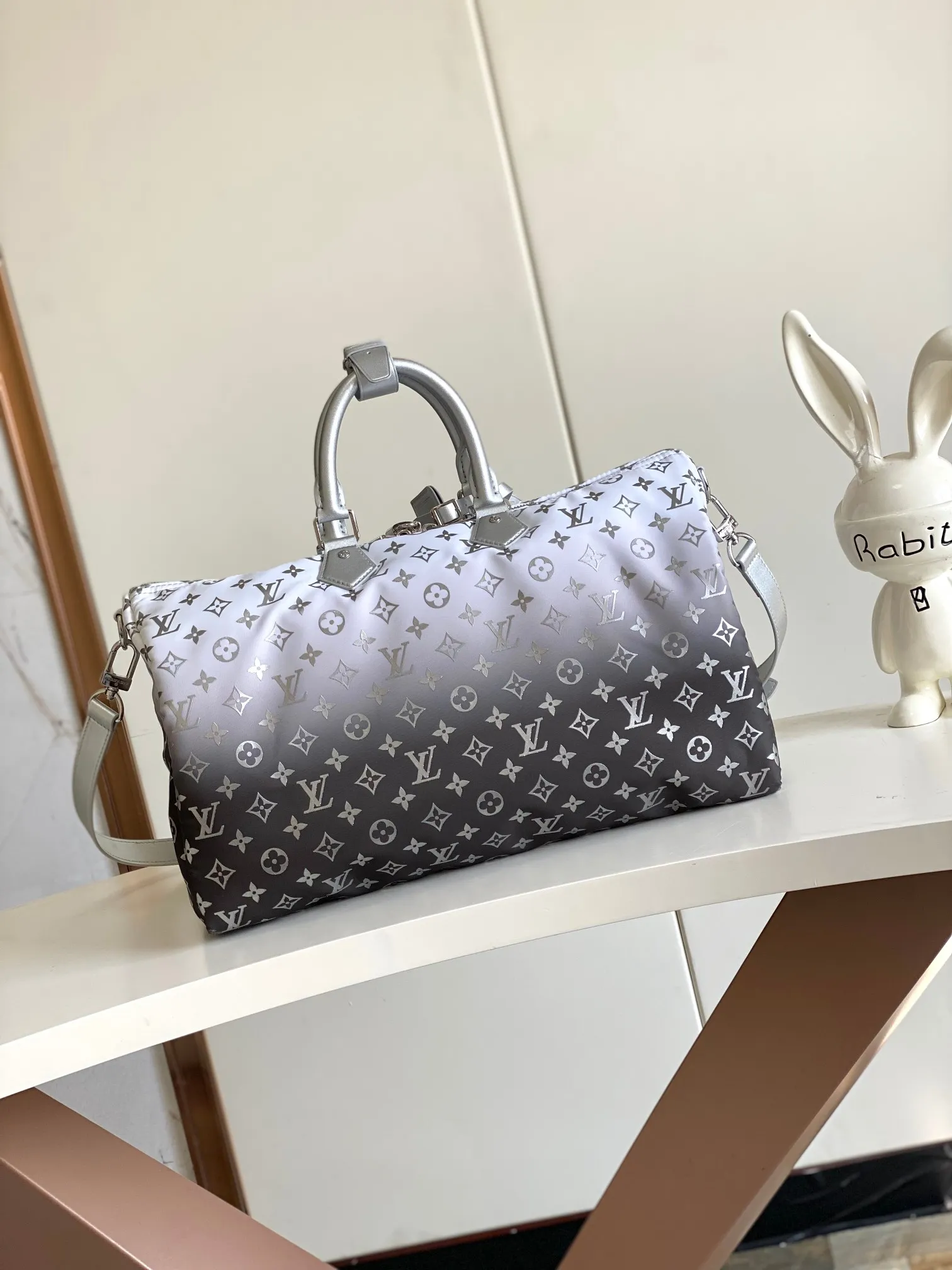 💰1260 Top original single dynamic chip M12067 silver This Keepall Bandoulière 45 travel bag is made of gradient effect Monogram nylon, with plain leather Monogram flower decoration to set off the winter mood. Durable and soft recycled nylon creates a close-fitting design, and the detachable leather strap allows for easy shoulder or cross-body wear.  27 cm