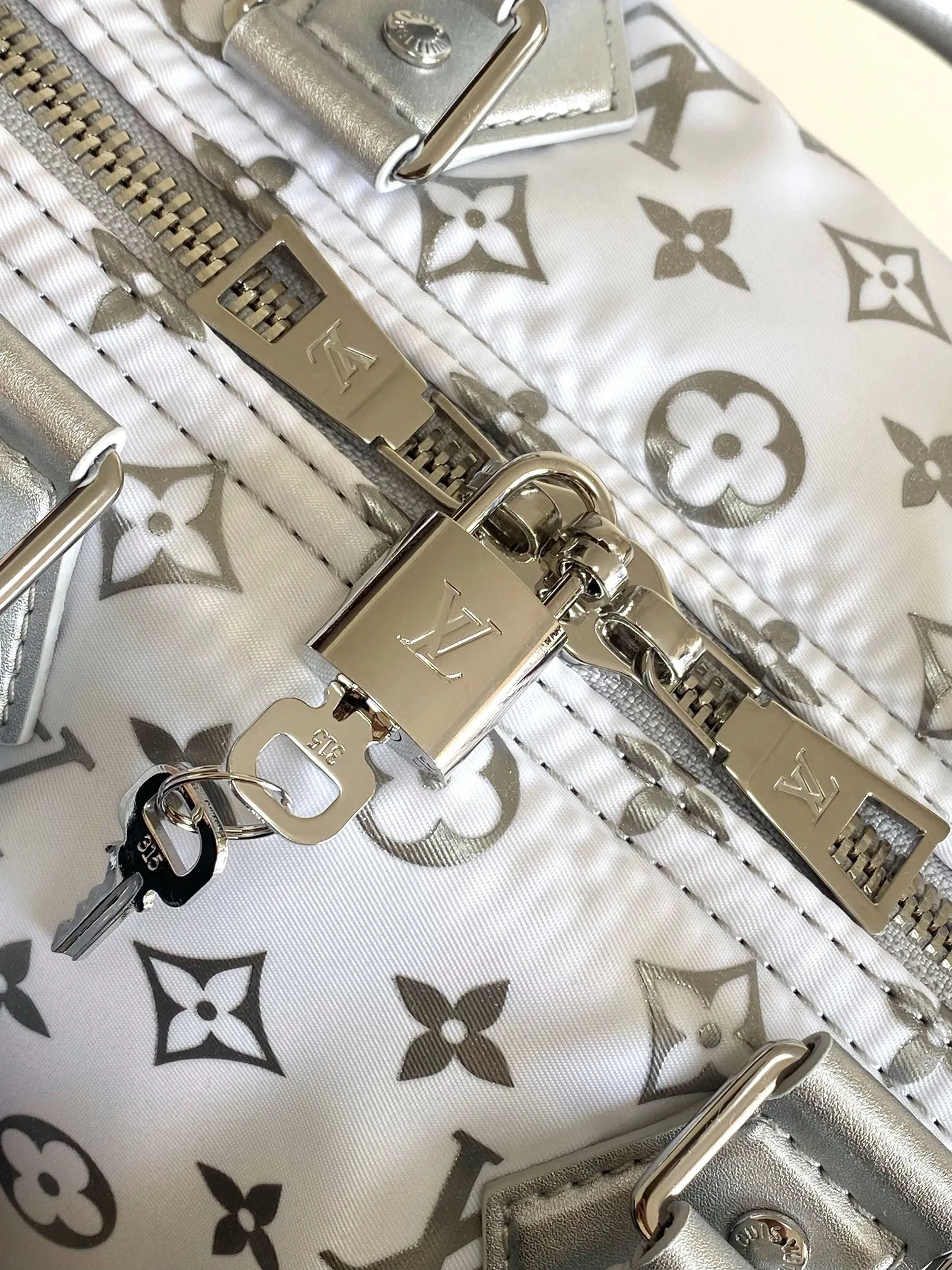 💰1260 Top original single dynamic chip M12067 silver This Keepall Bandoulière 45 travel bag is made of gradient effect Monogram nylon, with plain leather Monogram flower decoration to set off the winter mood. Durable and soft recycled nylon creates a close-fitting design, and the detachable leather strap allows for easy shoulder or cross-body wear.  27 cm