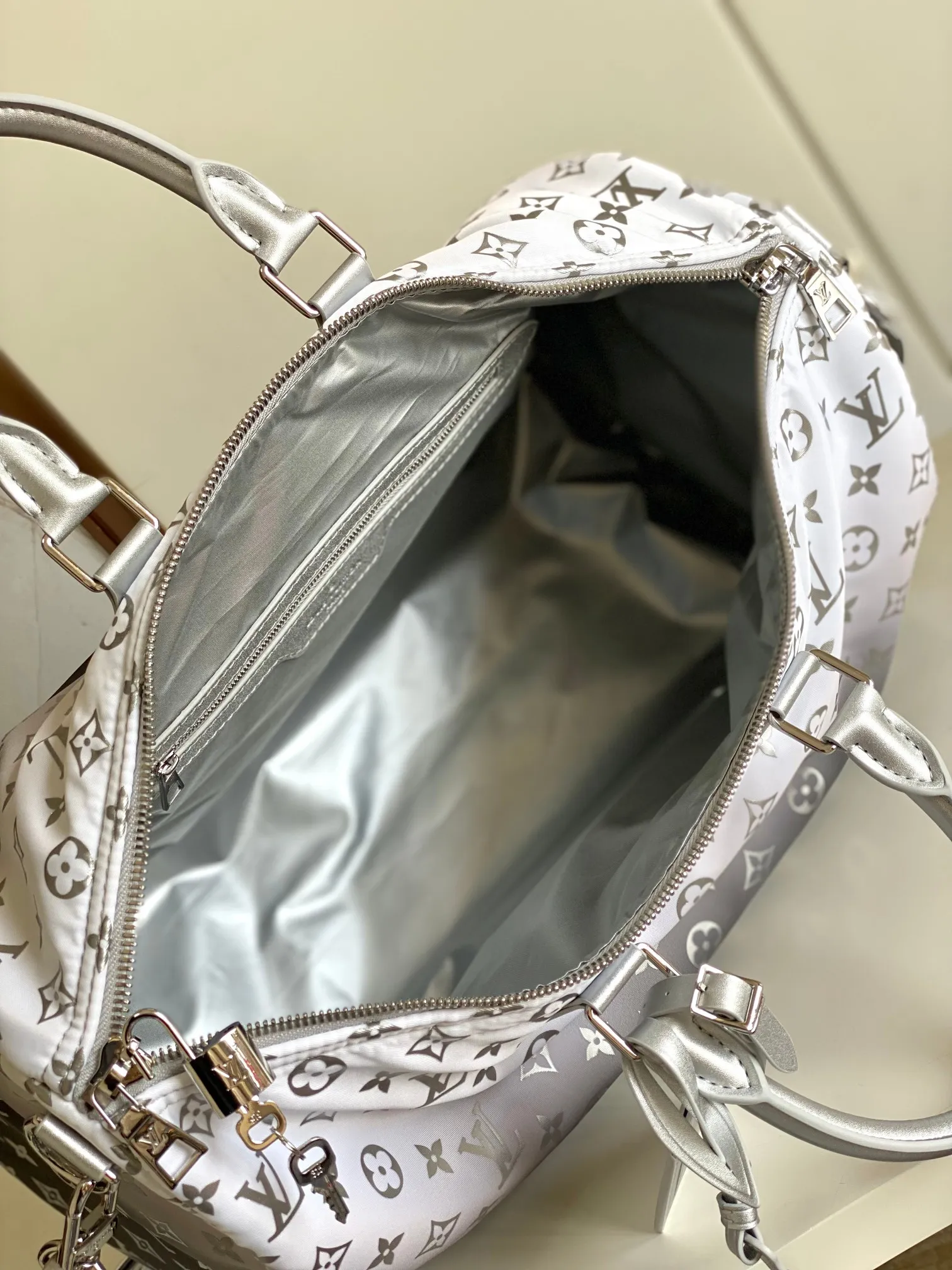 💰1260 Top original single dynamic chip M12067 silver This Keepall Bandoulière 45 travel bag is made of gradient effect Monogram nylon, with plain leather Monogram flower decoration to set off the winter mood. Durable and soft recycled nylon creates a close-fitting design, and the detachable leather strap allows for easy shoulder or cross-body wear.  27 cm