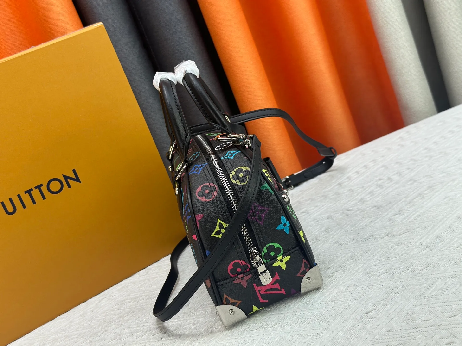 P280 Upgraded Original M13084 This Handbag East West handbag is from the Louis Vuitton x Takashi Murakami reissue series, using the artist's signature rainbow tones to trace the full-length Monogram pattern. Sleek horizontal construction lines the top handle, studded side straps, detachable and adjustable shoulder strap and LV x TM key holder, with cowhide leather details and sophisticated corners that nod to the brand's traditional luggage. Dimensions: 27.0 x 14.0 x 10.0 cm (length x height x width)