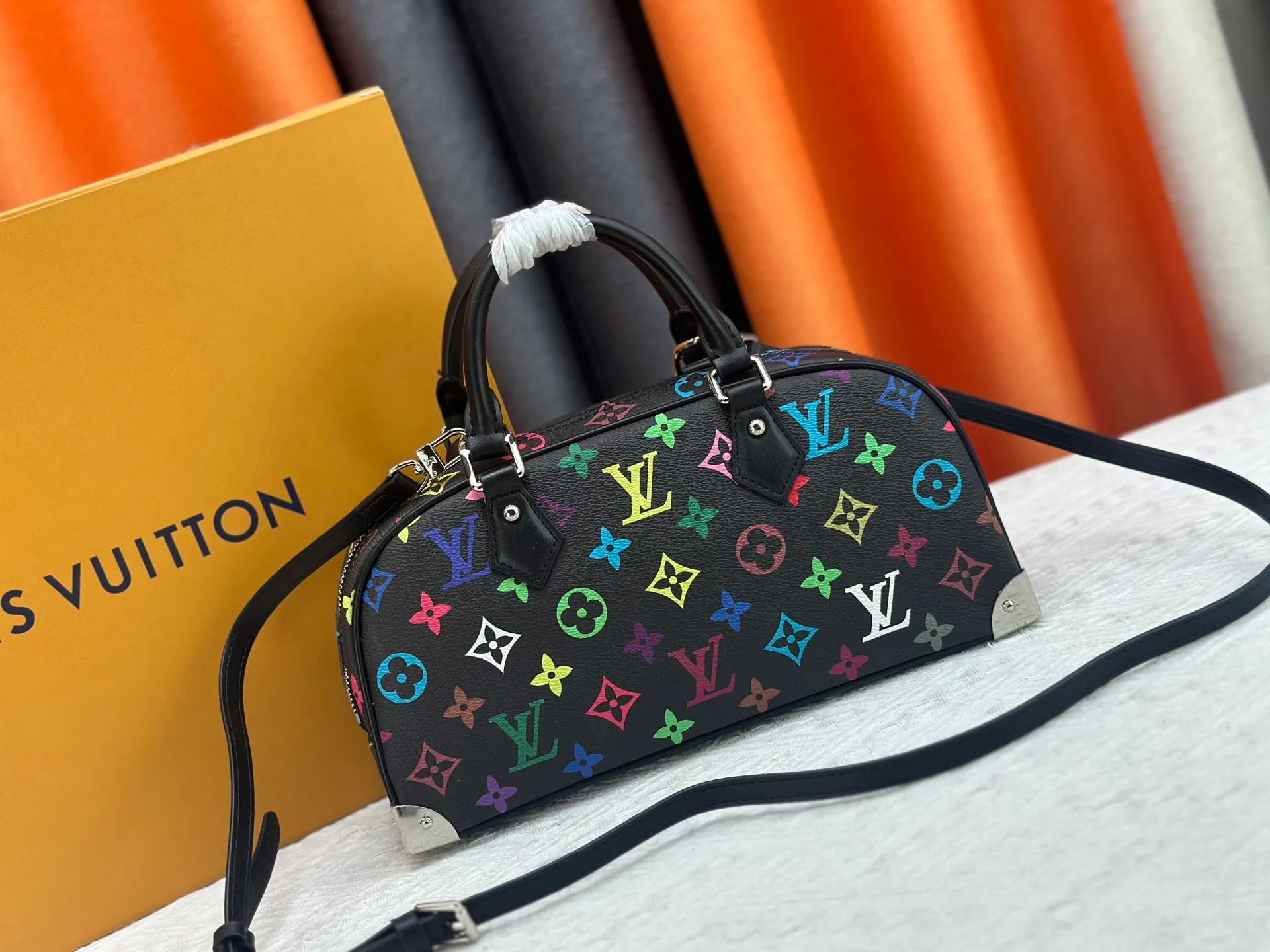 P280 Upgraded Original M13084 This Handbag East West handbag is from the Louis Vuitton x Takashi Murakami reissue series, using the artist's signature rainbow tones to trace the full-length Monogram pattern. Sleek horizontal construction lines the top handle, studded side straps, detachable and adjustable shoulder strap and LV x TM key holder, with cowhide leather details and sophisticated corners that nod to the brand's traditional luggage. Dimensions: 27.0 x 14.0 x 10.0 cm (length x height x width)