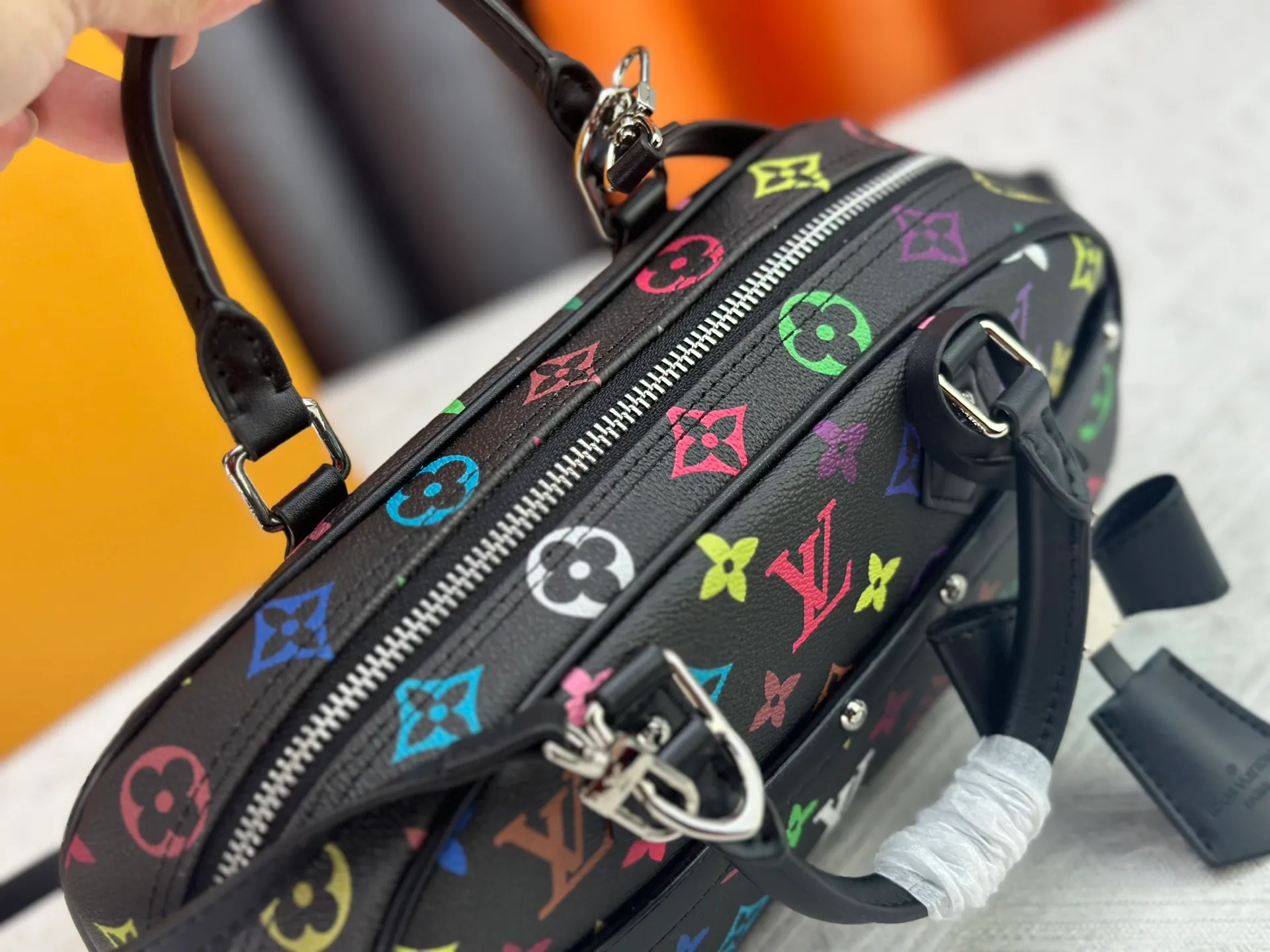 P280 Upgraded Original M13084 This Handbag East West handbag is from the Louis Vuitton x Takashi Murakami reissue series, using the artist's signature rainbow tones to trace the full-length Monogram pattern. Sleek horizontal construction lines the top handle, studded side straps, detachable and adjustable shoulder strap and LV x TM key holder, with cowhide leather details and sophisticated corners that nod to the brand's traditional luggage. Dimensions: 27.0 x 14.0 x 10.0 cm (length x height x width)