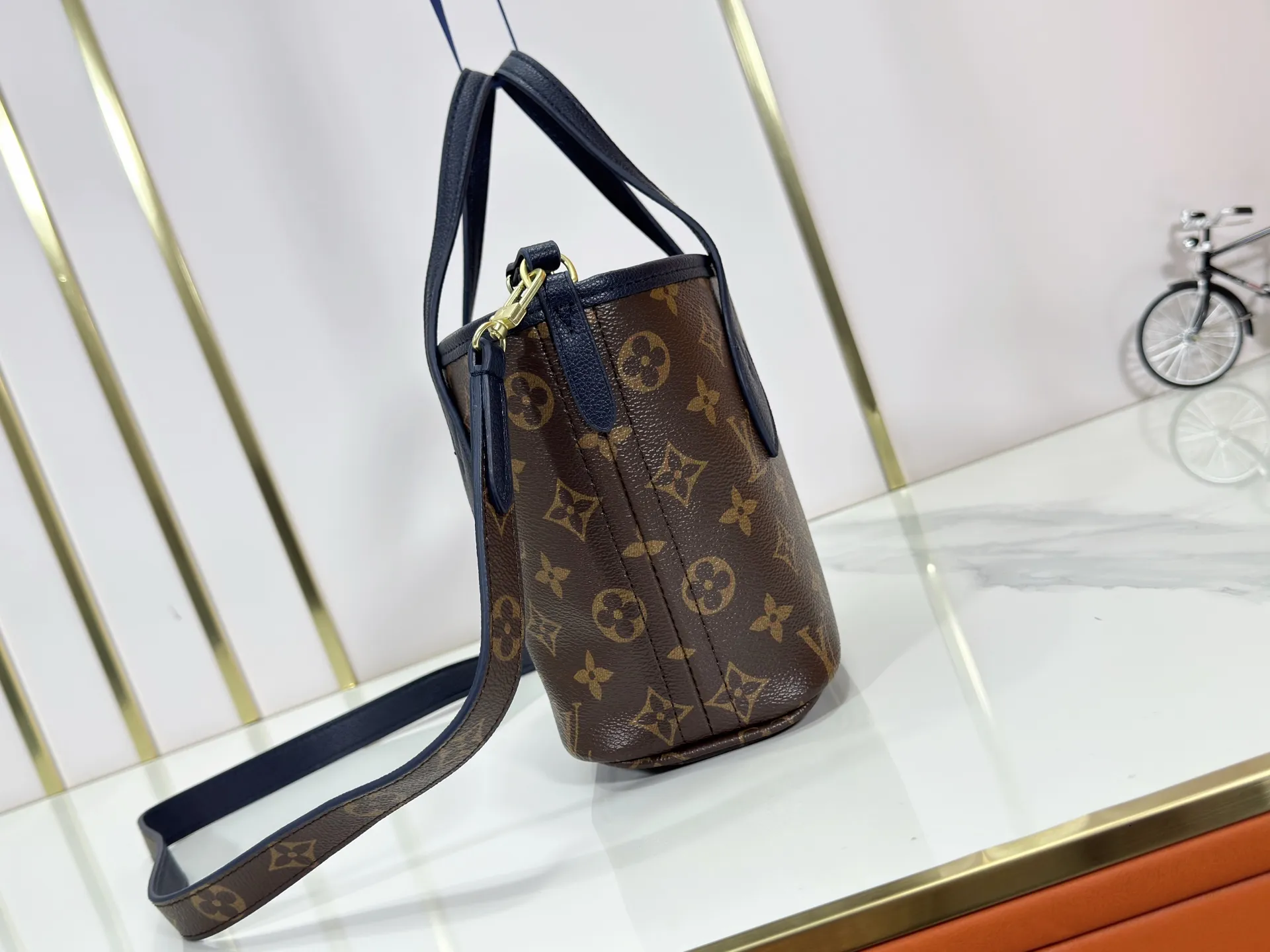 P220 M12099 Upgraded original Neverfull Bandouliere Inside Out BB handbag is a double-sided version of the classic design this season, with the front and back decorated with iconic Monogram canvas and grained leather. The removable zipper bag can be used alone or hung externally. The detachable shoulder strap makes it easy to wear cross-body, and the dazzling metal hardware adds a sophisticated detail. Dimensions: 24 × 14 × 9 cm