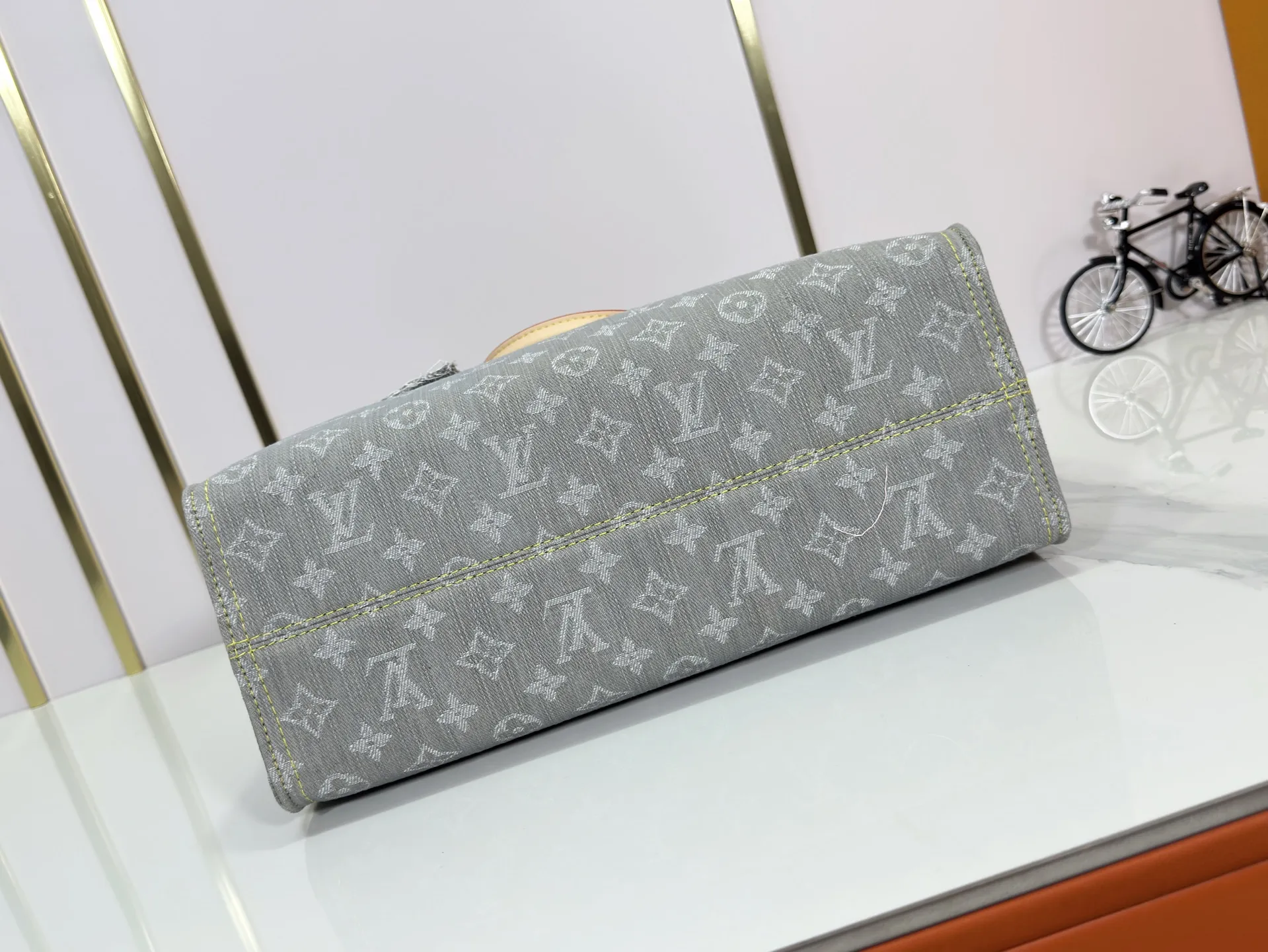 P320 M49495 M45659 M13189 New Gray Denim Denim This edition of OnTheGo MM celebrates the return of the iconic Monogram denim pattern in 2005. It's made from organic cotton, artfully woven with black and white threads and then bleached using a special Louis Vuitton technique to create a vintage-inspired finish. It's sized to hold a laptop, features light gold hardware, and includes signature details like natural leather accents and a removable name tag. Dimensions: 35 x 27 x 14 cm