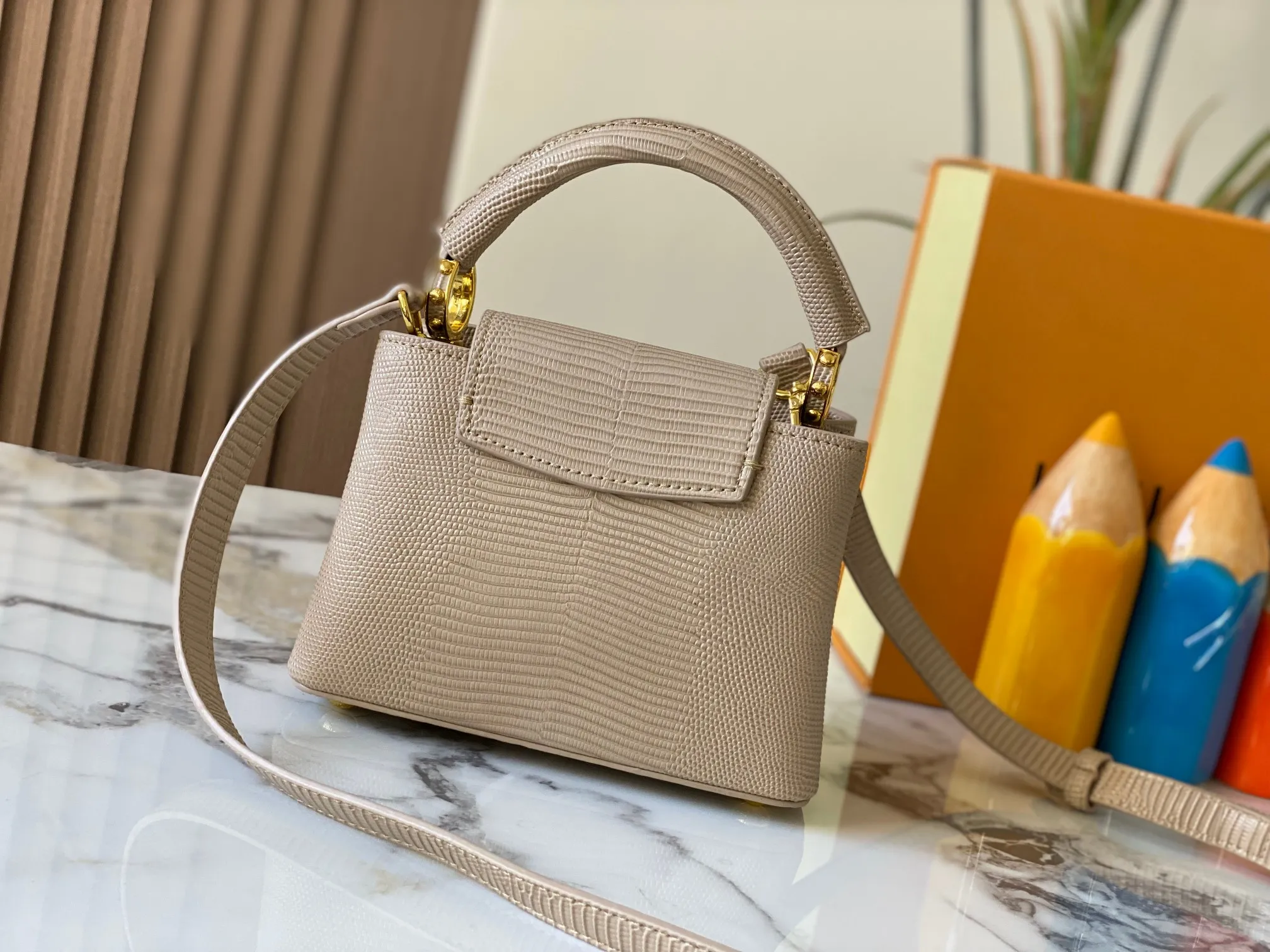 Top original P420 Guangzhou product M99527 apricot lizard gold buckle This Capucines mini handbag is wrapped in gorgeous lizard leather and lined with fine sheepskin, embellished with dazzling metal parts. The flip cover reads LV letters inside, and a Monogram flower blooms when turned out. Its compact size makes it a dazzling choice for evening occasions. Detailed features 21 x 14 x 8 cm (length x height x width)