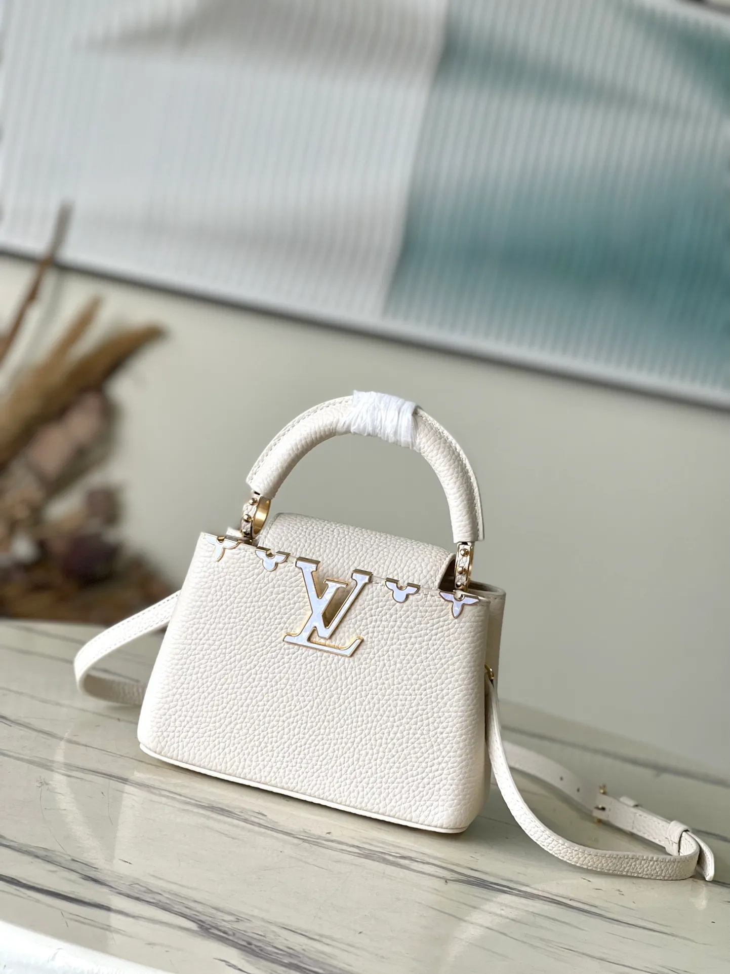 💰2160 (Special grade original leather) M23331/M48865 White with white mother-of-pearl corolla This Capucines Flower Crown handbag is made of full-grain Taurillon leather and is embellished with Monogram flowers. Each flower is made of exquisite shells. The LV logo and flowers echo each other, giving this feminine handbag a jewel-like luster. Use the detachable shoulder strap cleverly to carry it cross-body. Size: 21 * 14*8cm